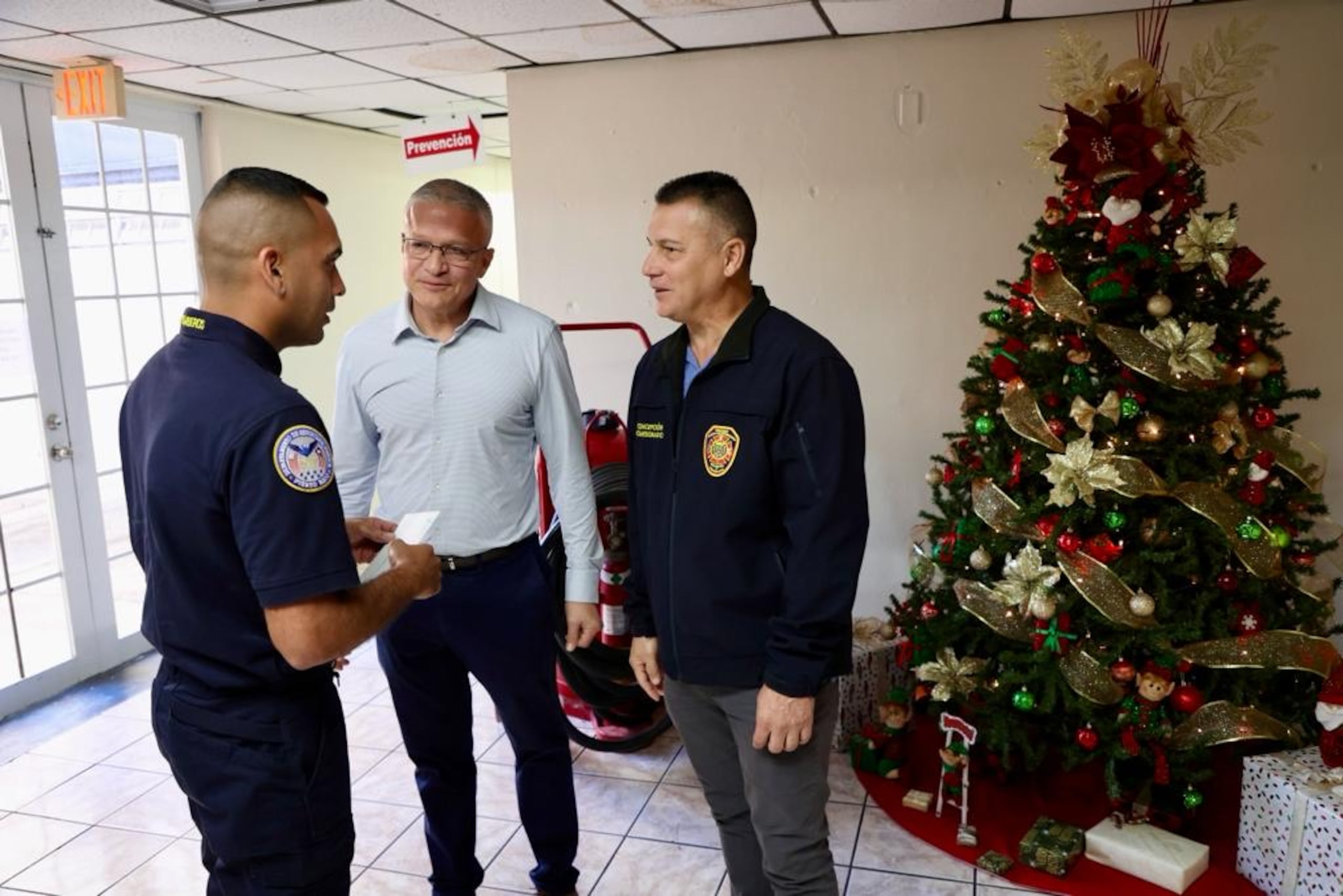 Alexis Torres, secretario del Departamento de Seguridad Pública, y Marcos Concepción Tirado, comisionado del Negociado del Cuerpo de Bomberos, conversan con un bombero.