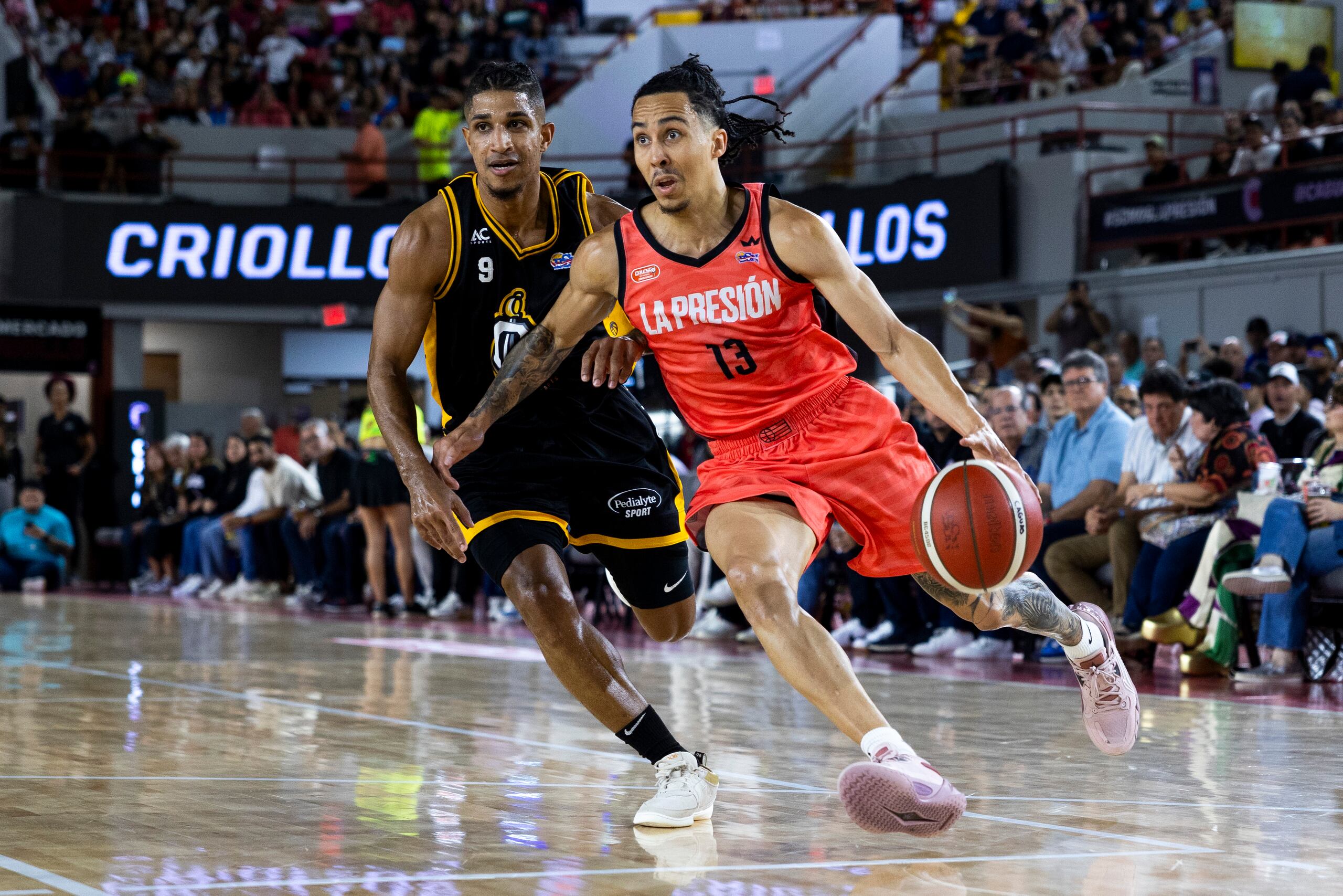Travis Trice, de los Criollos de Caguas, busca atacar el canasto mientras es perseguido por Alfonso Plummer, de los Capitanes de Arecibo.