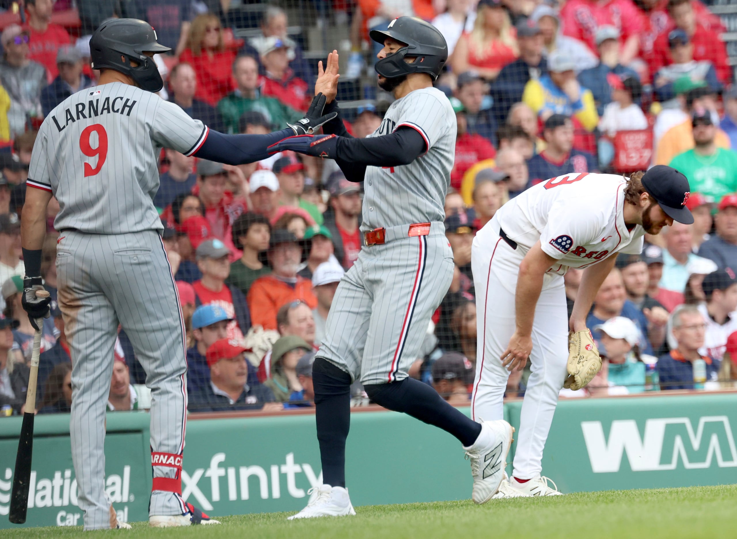 Justin Slaten, derecha, lanzador de Red Sox de Boston, reacciona mientras el campocorto de Twins de Minnesota, Carlos Correa, centro, celebra con Trevor Larnach (9) después de anotar carrera durante la octava entrada del juego de béisbol de Grandes Ligas el domingo 4 de mayo de 2025, en Boston.