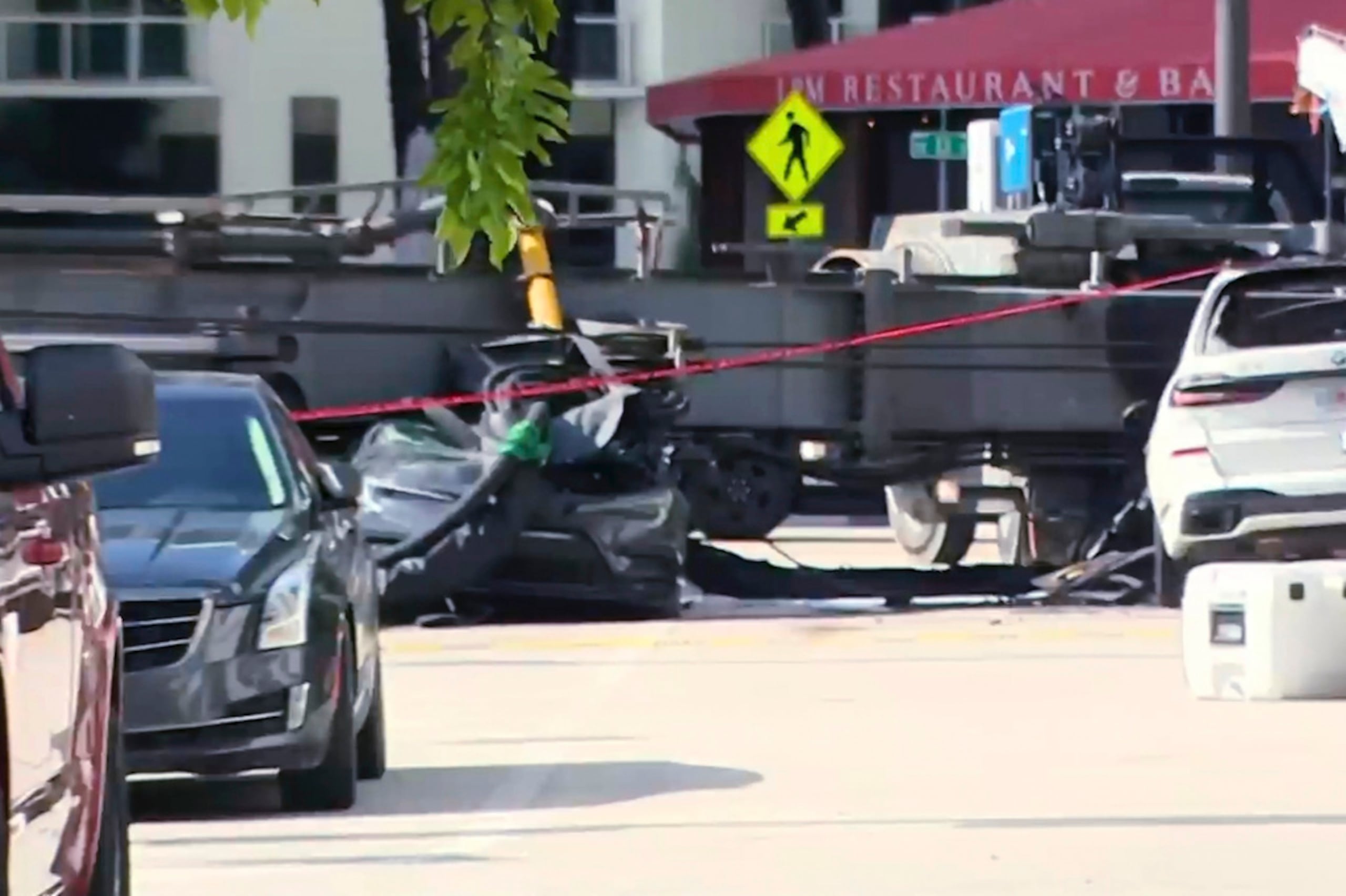 Esta imagen, tomada de un video de WSVN, muestra un vehículo aplastado luego de que una grúa colapsara en una obra de construcción en Miami el lunes 14 de septiembre de 2026.