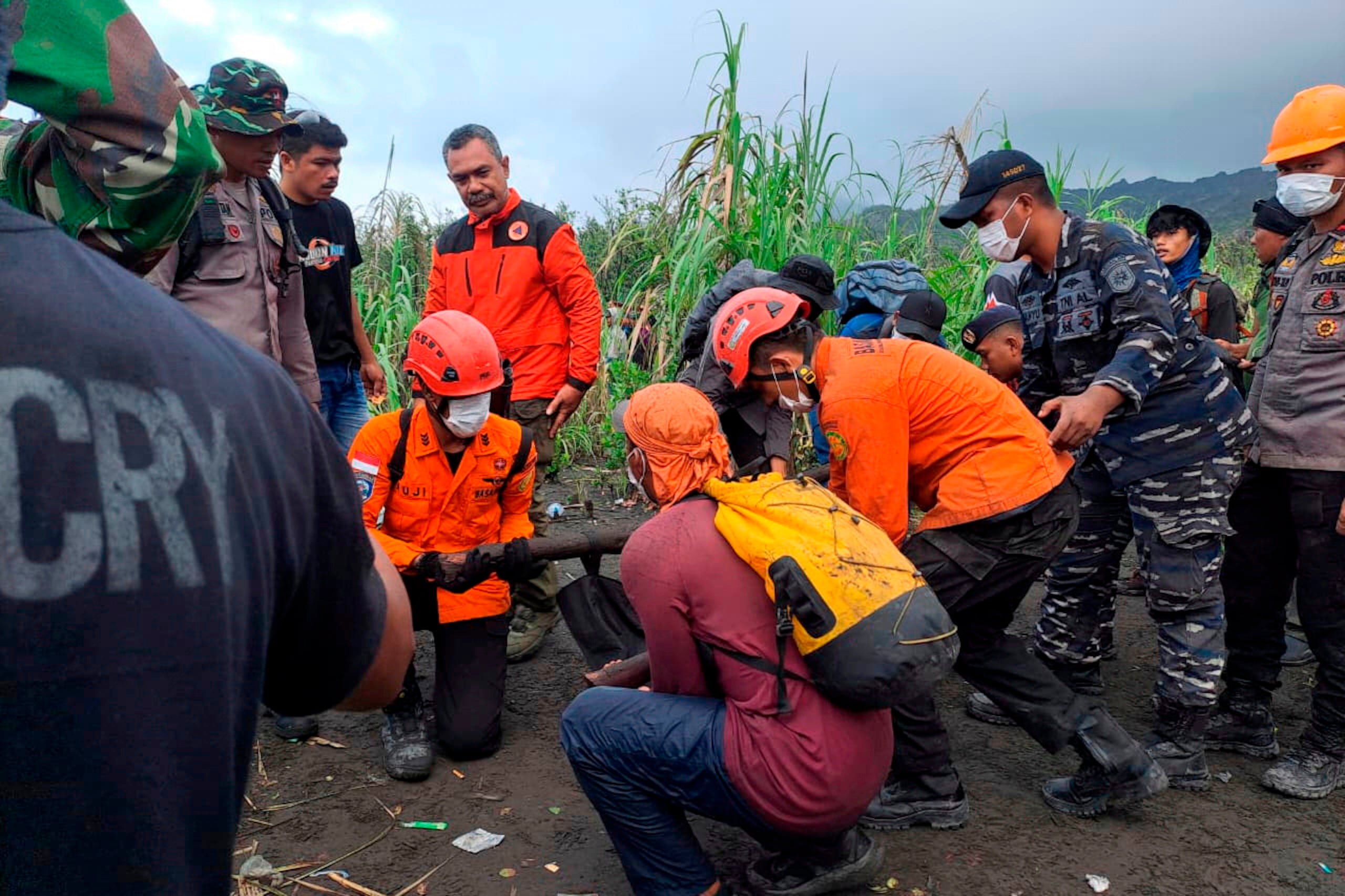En esta imagen publicada por la Agencia Nacional Indonesia de Búsqueda y Rescate (BASARNAS), rescatistas cargan el cuerpo de una víctima de la erupción del monte Dukono, en la isla de Halmahera, Indonesia, el sábado 9 de mayo de 2026. (BASARNAS via AP)