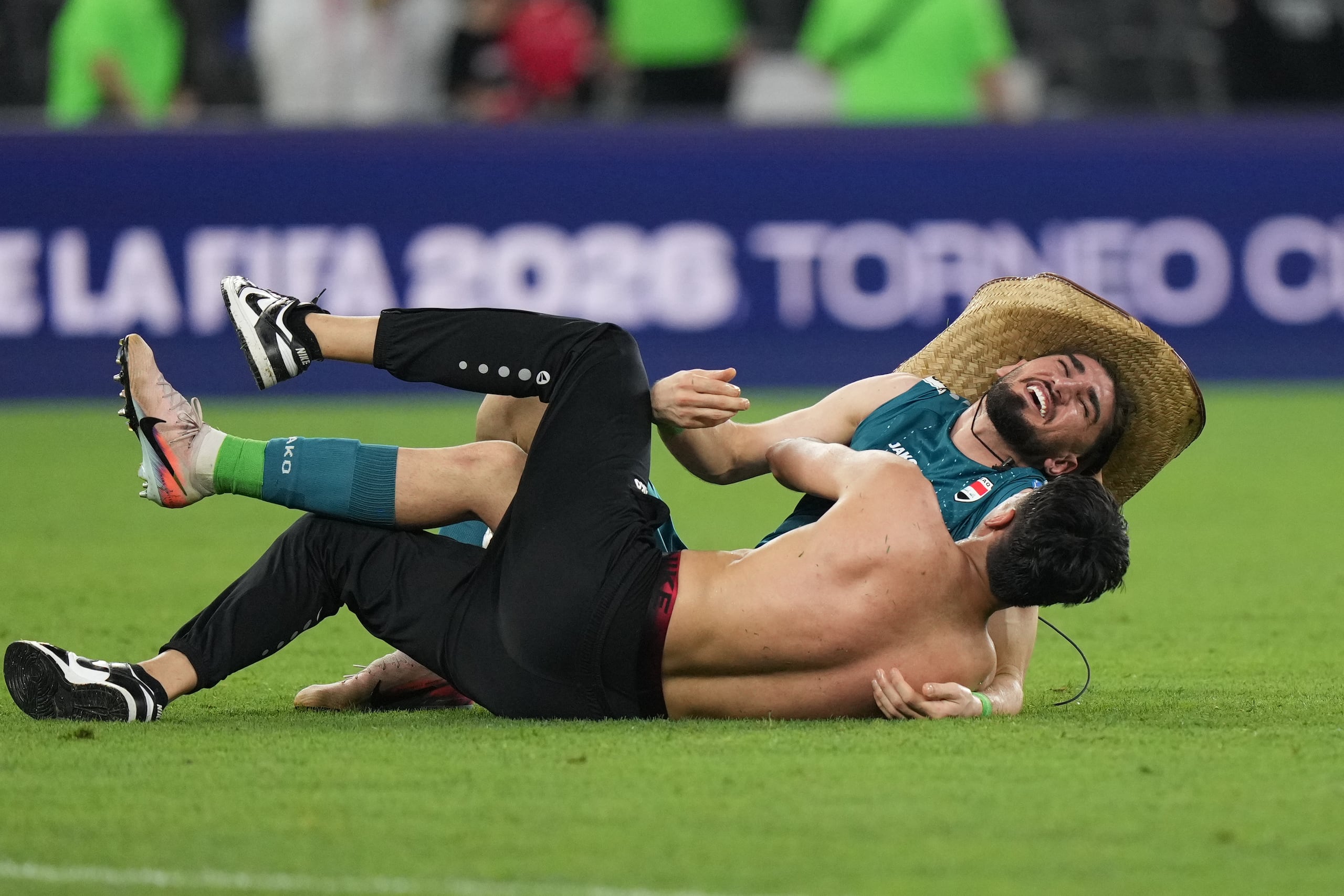 Akram Hashim (arriba) feteja con un aficionado, luego de sellar su pasaje de Irak al Mundial con un triunfo sobre Bolivia en el repechaje, el martes 31 de marzo de 2026, en Monterrey, México (AP Foto/Fernando Llano)