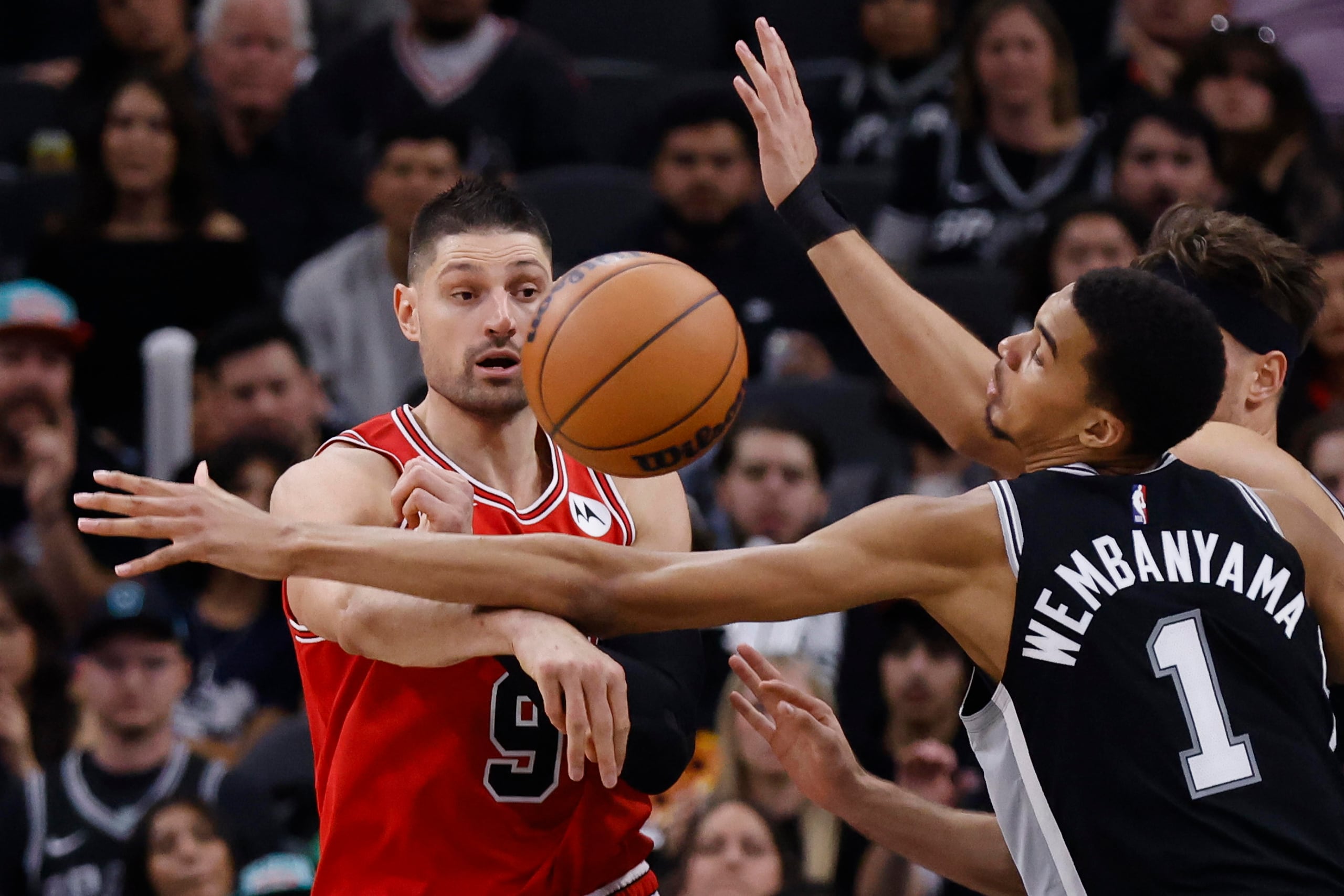 El centro de Chicago Bulls Nikola Vucevic (i) pasa el balón pasando por el centro de San Antonio Spurs Victor Wembanyama (d) durante la segunda mitad de un partido la noche del viernes.