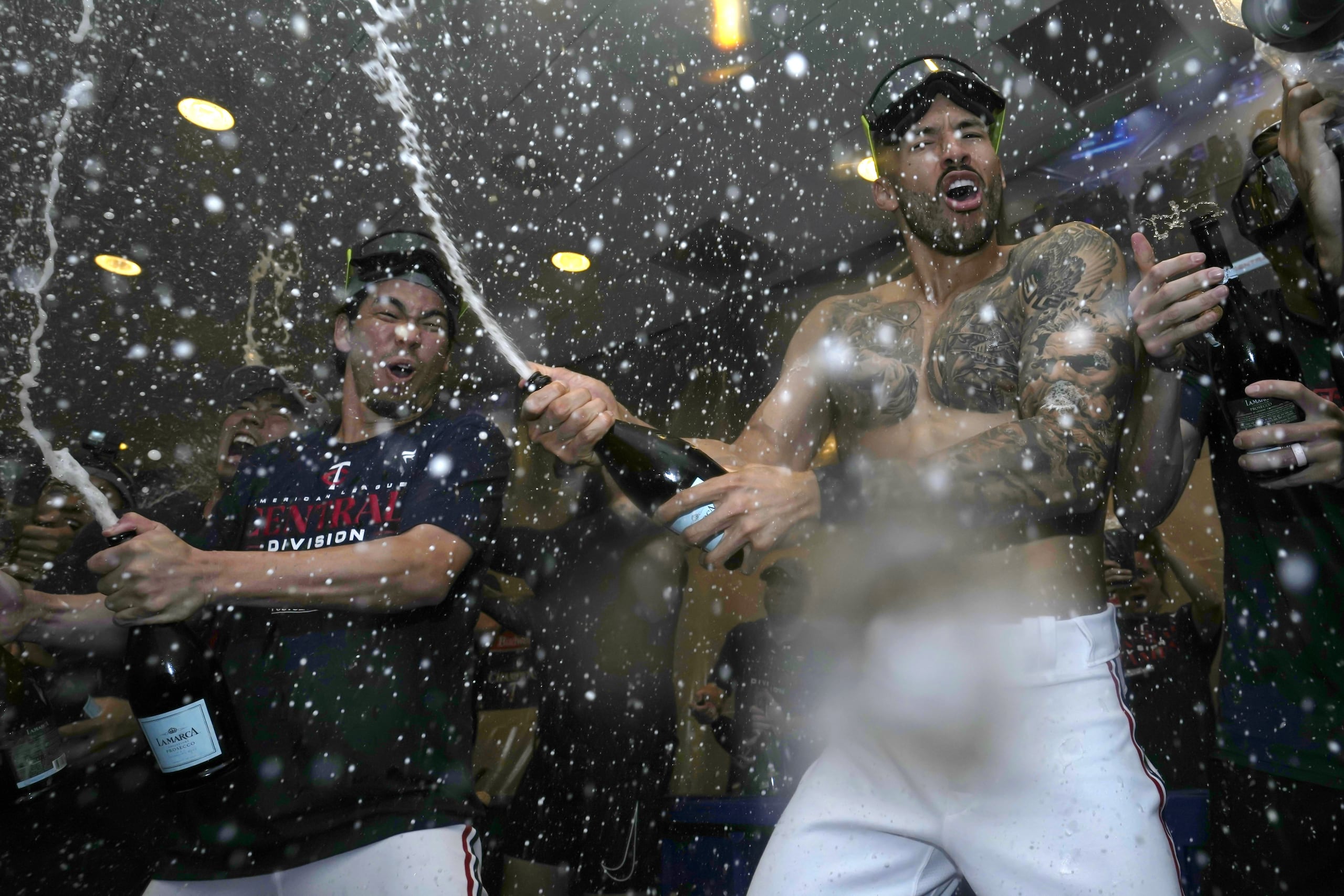 El boricua Carlos Correa (derecha) y el japonés Kenta Maeda (izquierda) celebran el título divisional de los Twins.