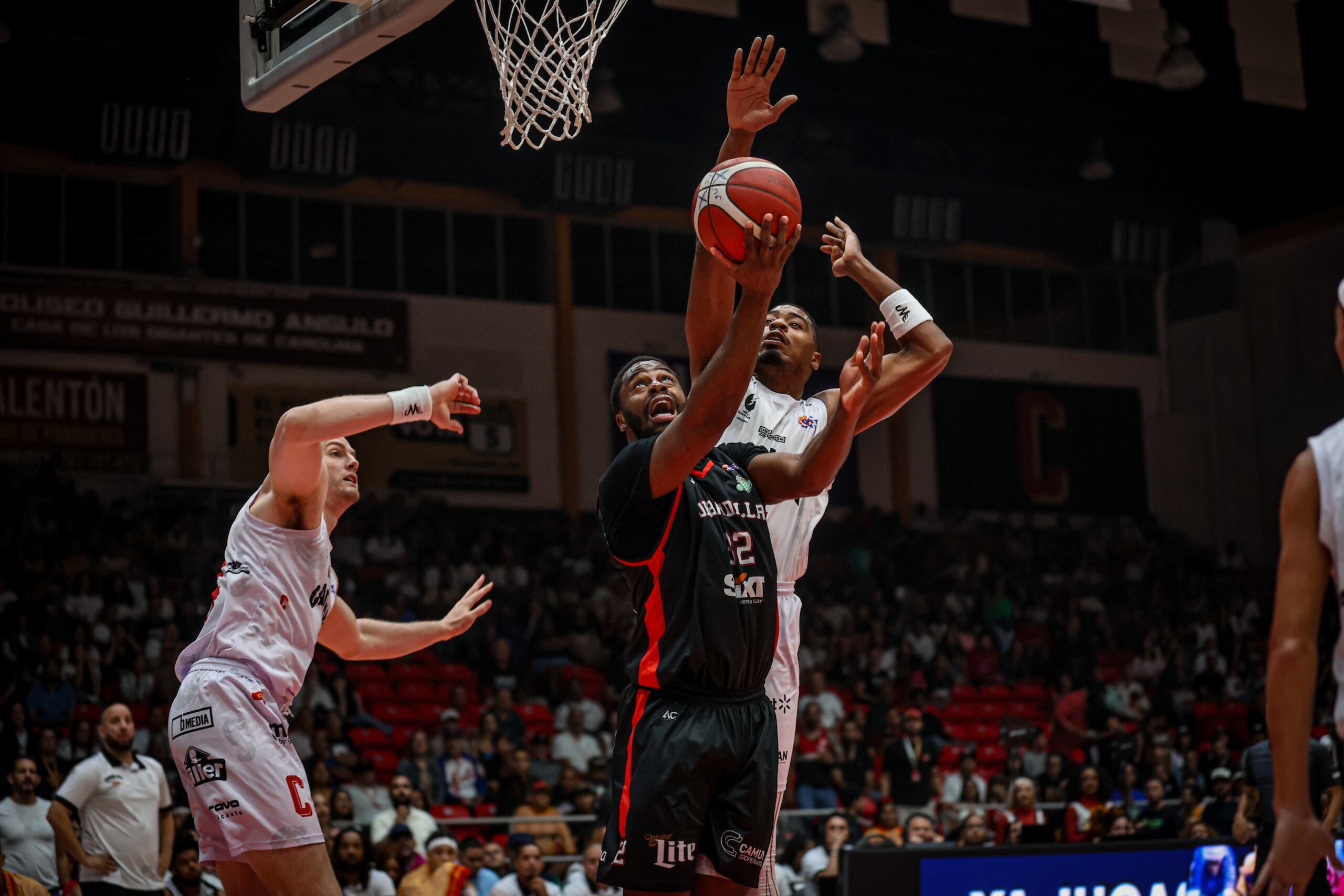 Emmanuel Mudiay ataca el canasto ante la defensa de los Gigantes de Carolina.