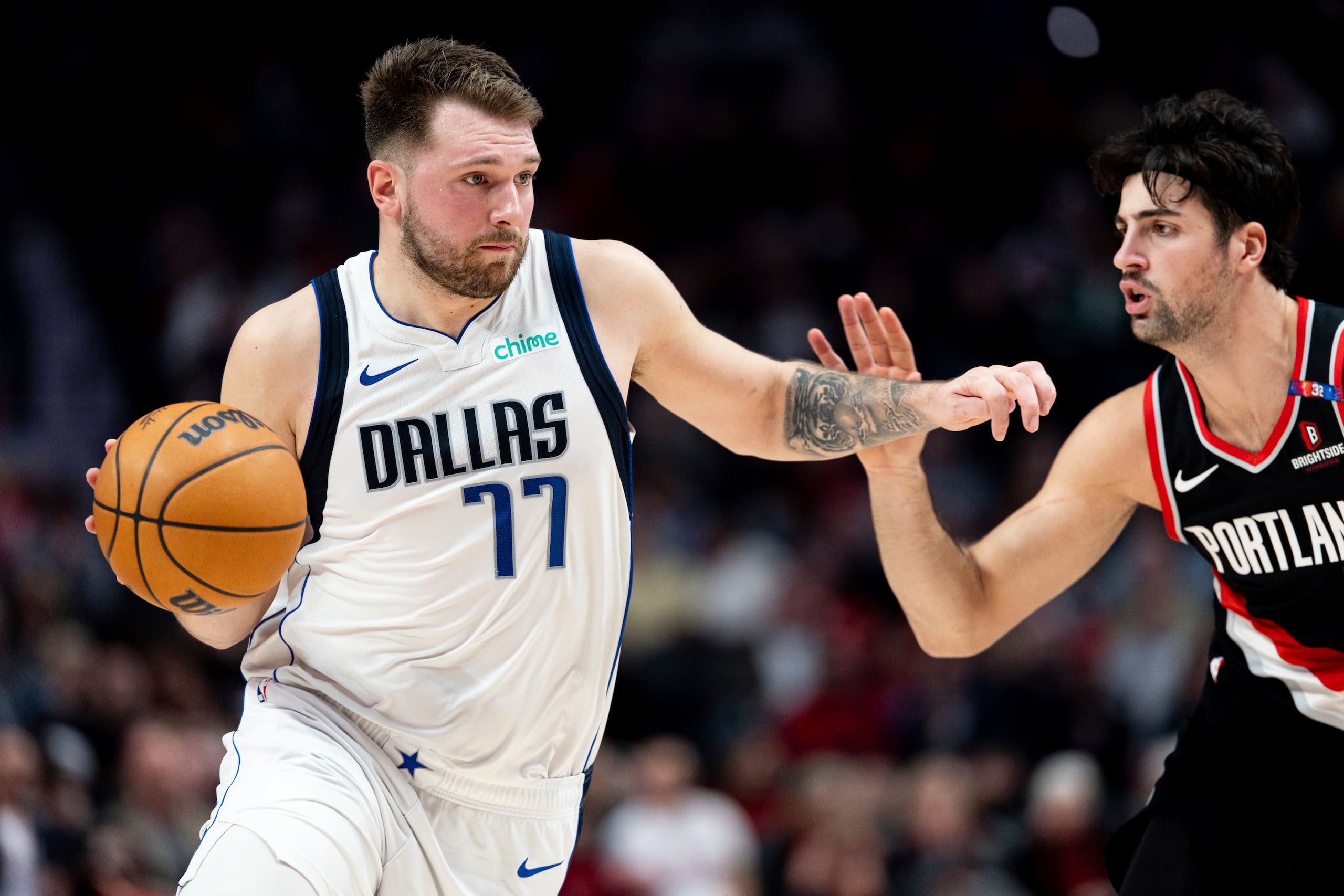 Luka Doncic, izquierda, de los Mavericks de Dallas, conduce el balón frente a Deni Avdija, derecha, de los Trail Blazers de Portland, durante la primera mitad del juego de baloncesto de la NBA, el domingo 1 de diciembre de 2024, en Portland, Oregon. (AP Foto/Howard Lao)