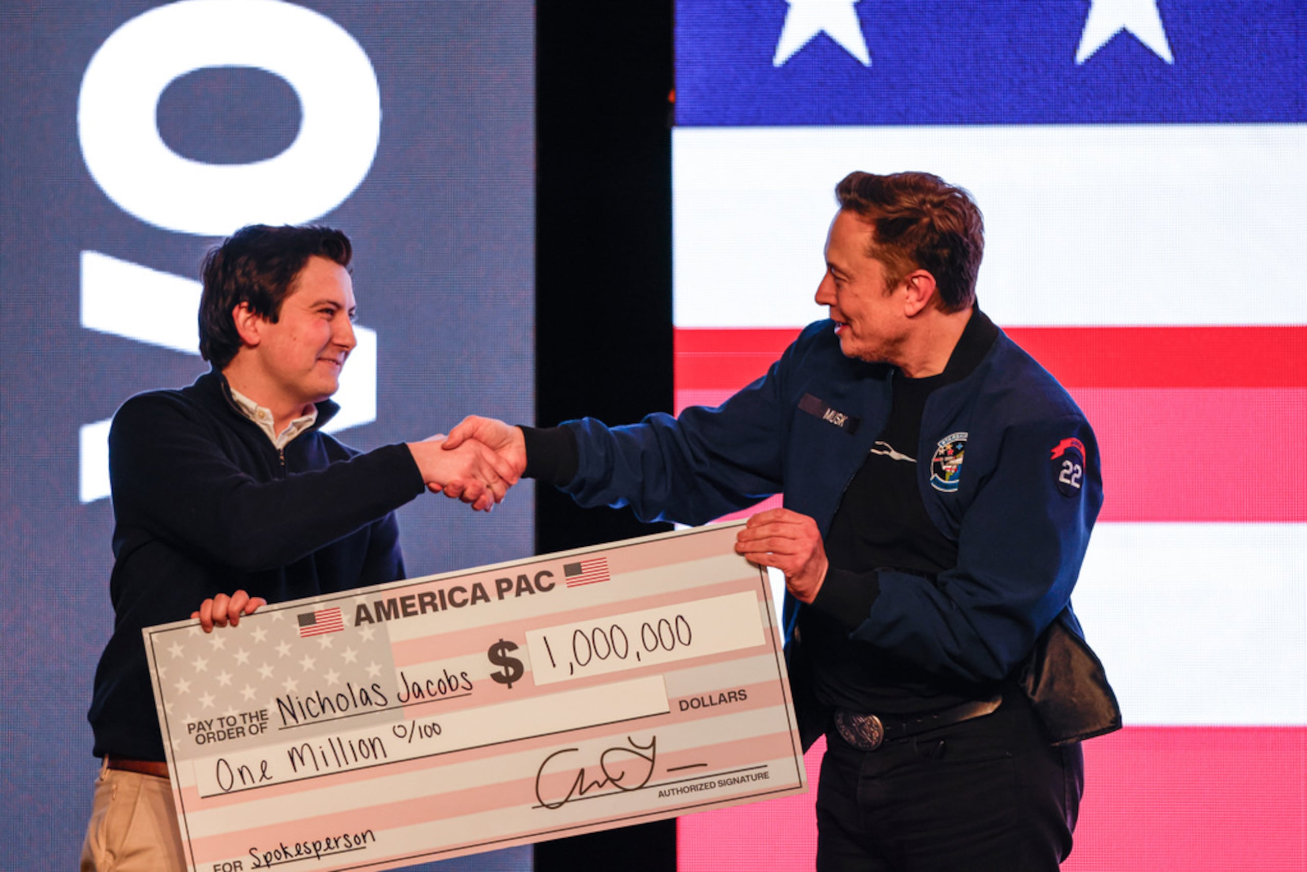 Elon Musk presenta un cheque por 1 millón de dólares a un hombre durante una reunión pública el 30 de marzo de 2025, en Green Bay, Wisconsin.