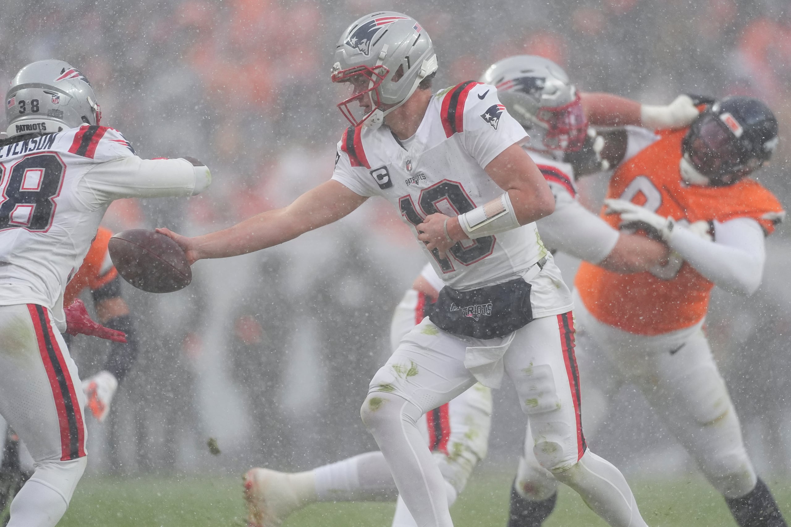 El quarterbacks de los Patriots, Drake Maye (10), entrega el balón durante la segunda mitad del partido por el Campeonato de la AFC de la NFL frente a los Denver Broncos.