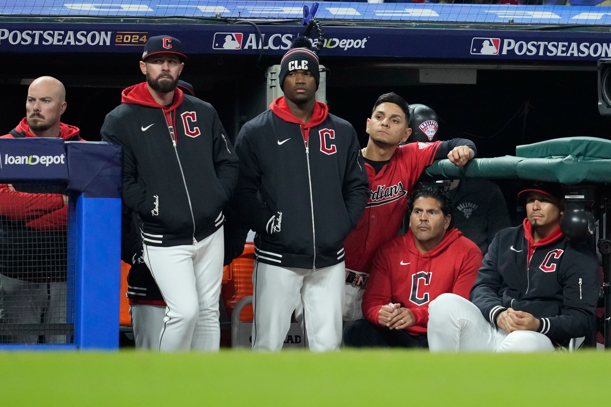 Los jugadores de los Guardians de Cleveland observan a los Yankees celebrando desde el banco tras su eliminación.