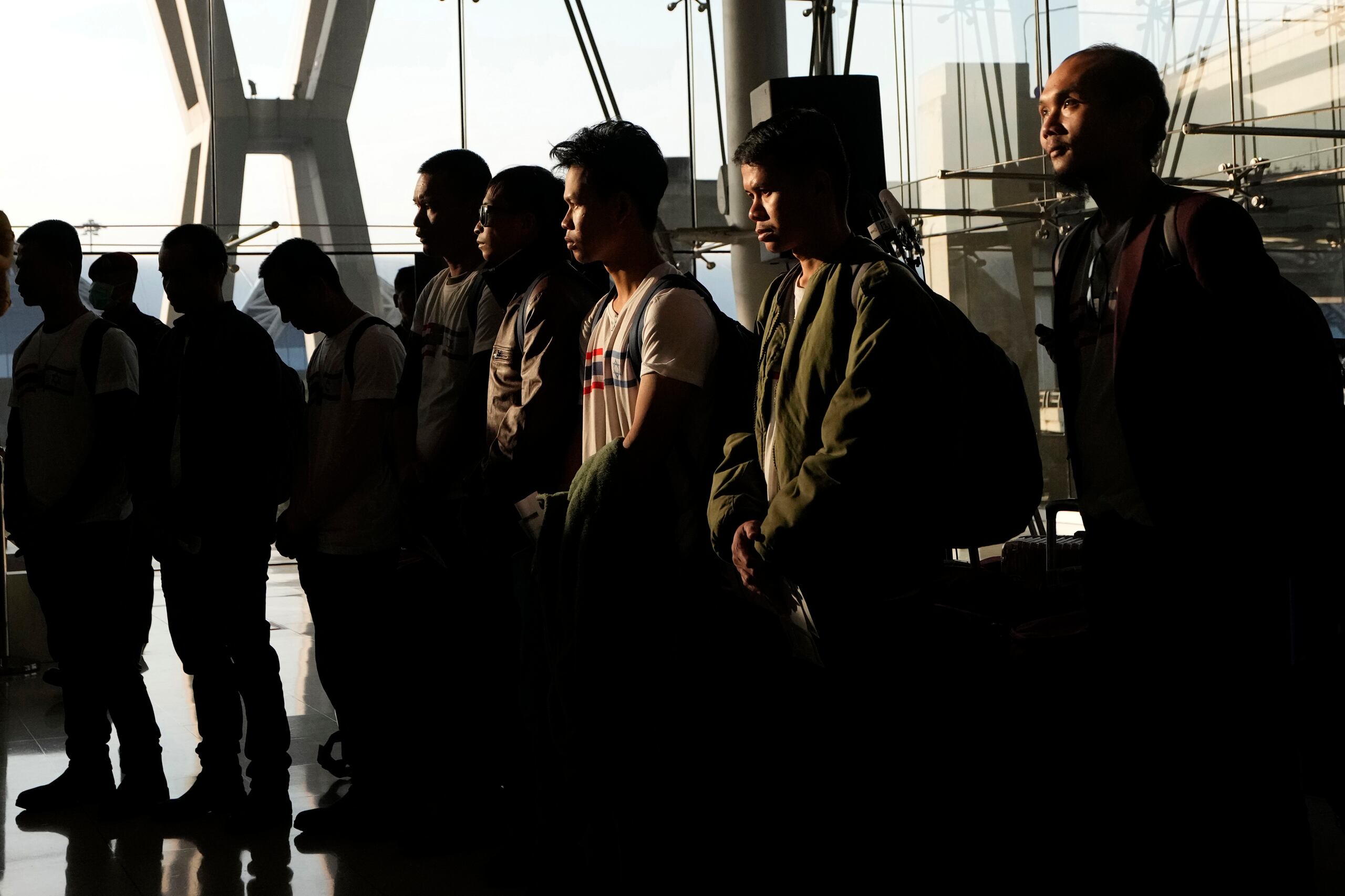 Rehenes tailandeses que fueron liberados por Hamás guardan un minuto de silencio a su llegada al Aeropuerto Internacional Suvarnabhumi, en la provincia de Samut Prakarn, Tailandia, el jueves 30 de noviembre de 2023. (AP Foto/Sakchai Lalit)