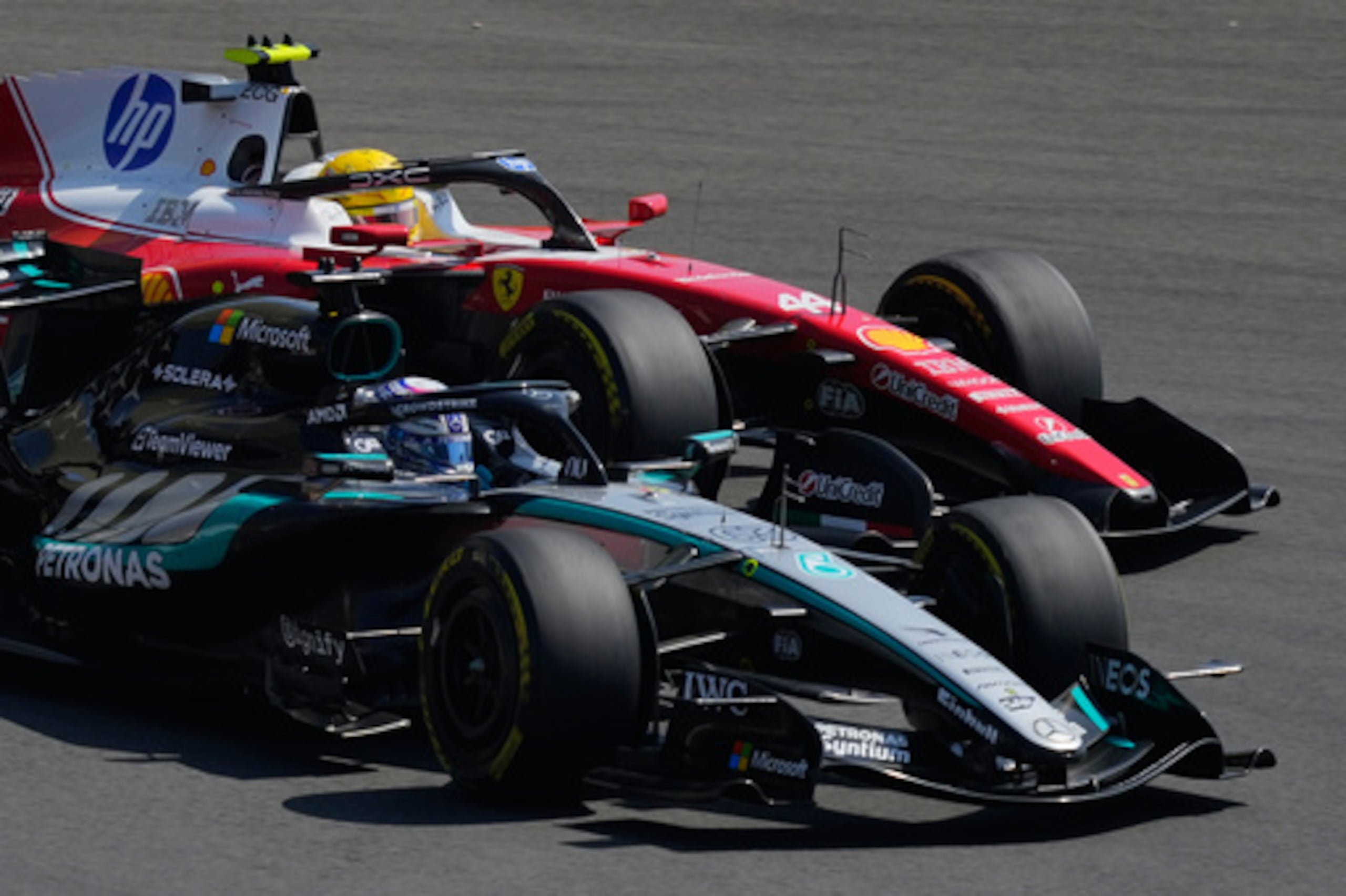 El británico Gerorge Russell (izquierda) disputa en su Mercedes la punta a su compatriota Lewis Hamilton, de Ferrari, durante el sprint del Gran Premio de China, el sábado 14 de marzo de 2026 (AP Foto/Vincent Thian)