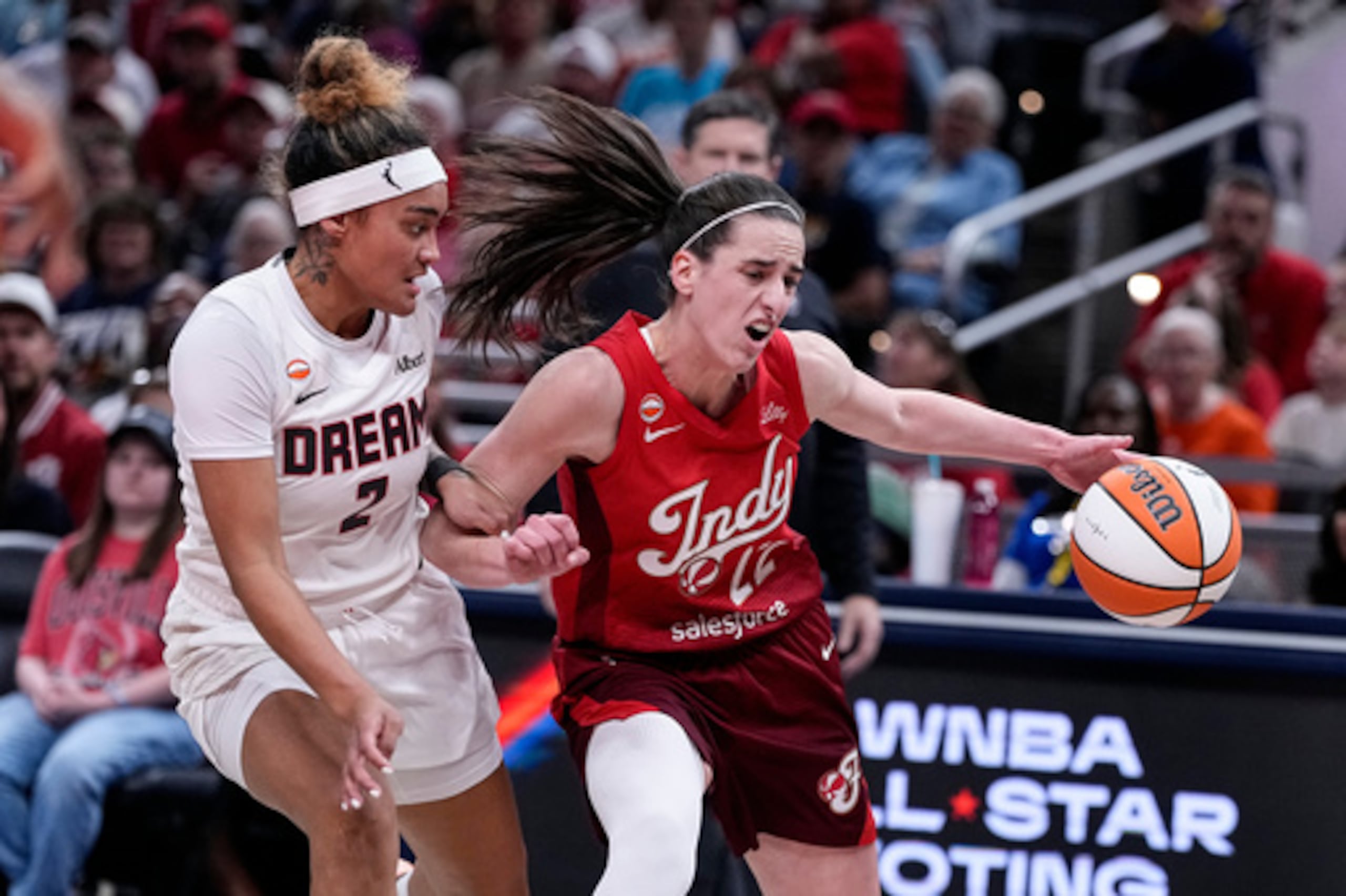 La base del Indiana Fever, Caitlin Clark (22), penetra ante la base del Atlanta Dream, Te-Hina Paopao (2), durante la primera parte de un partido de baloncesto de la WNBA disputado en Indianápolis el jueves 18 de junio de 2026. (Foto AP/Michael Conroy)
