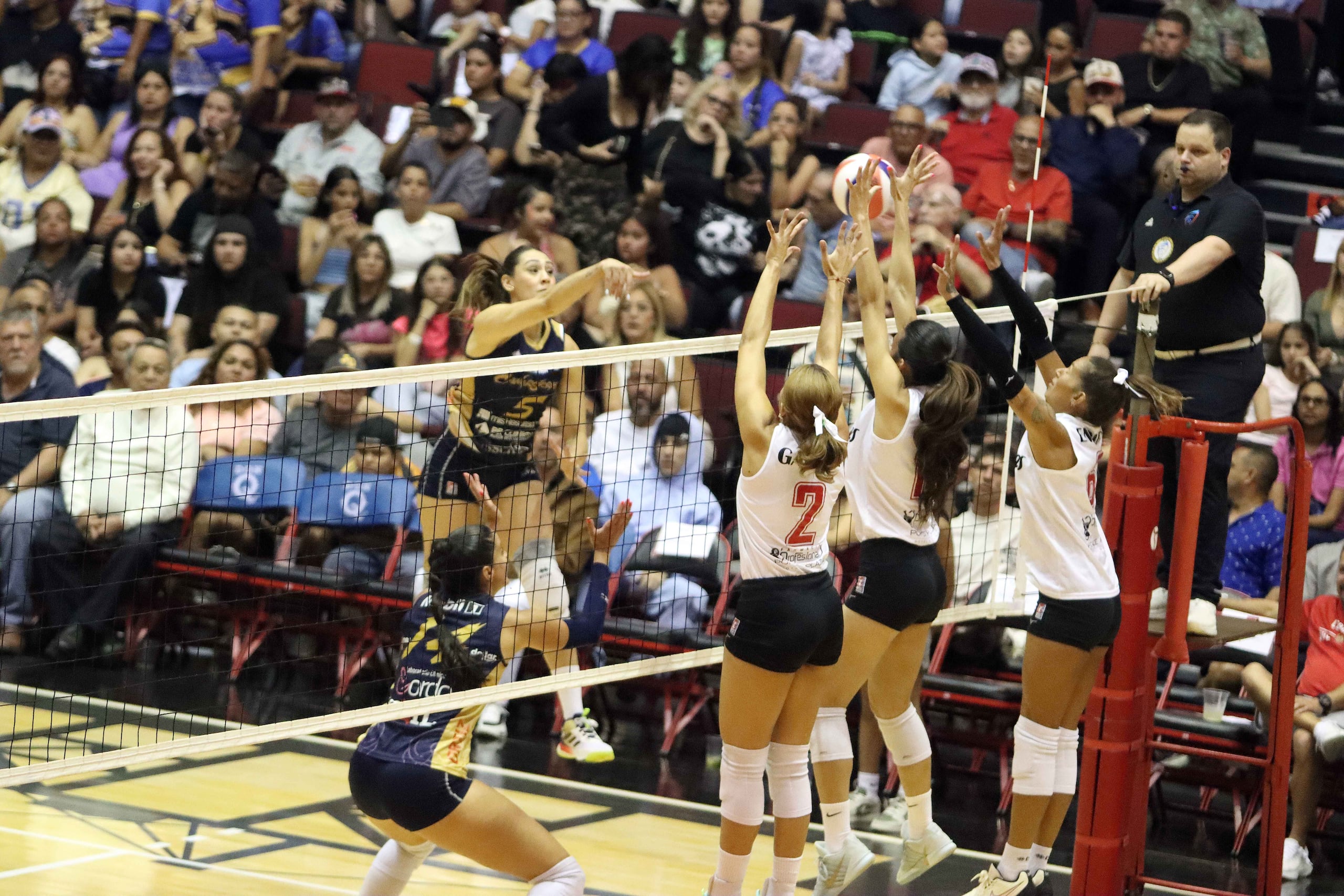 Andrea Rangel de las Cangrejeras ataca contra el triple bloqueo de Ponce.
