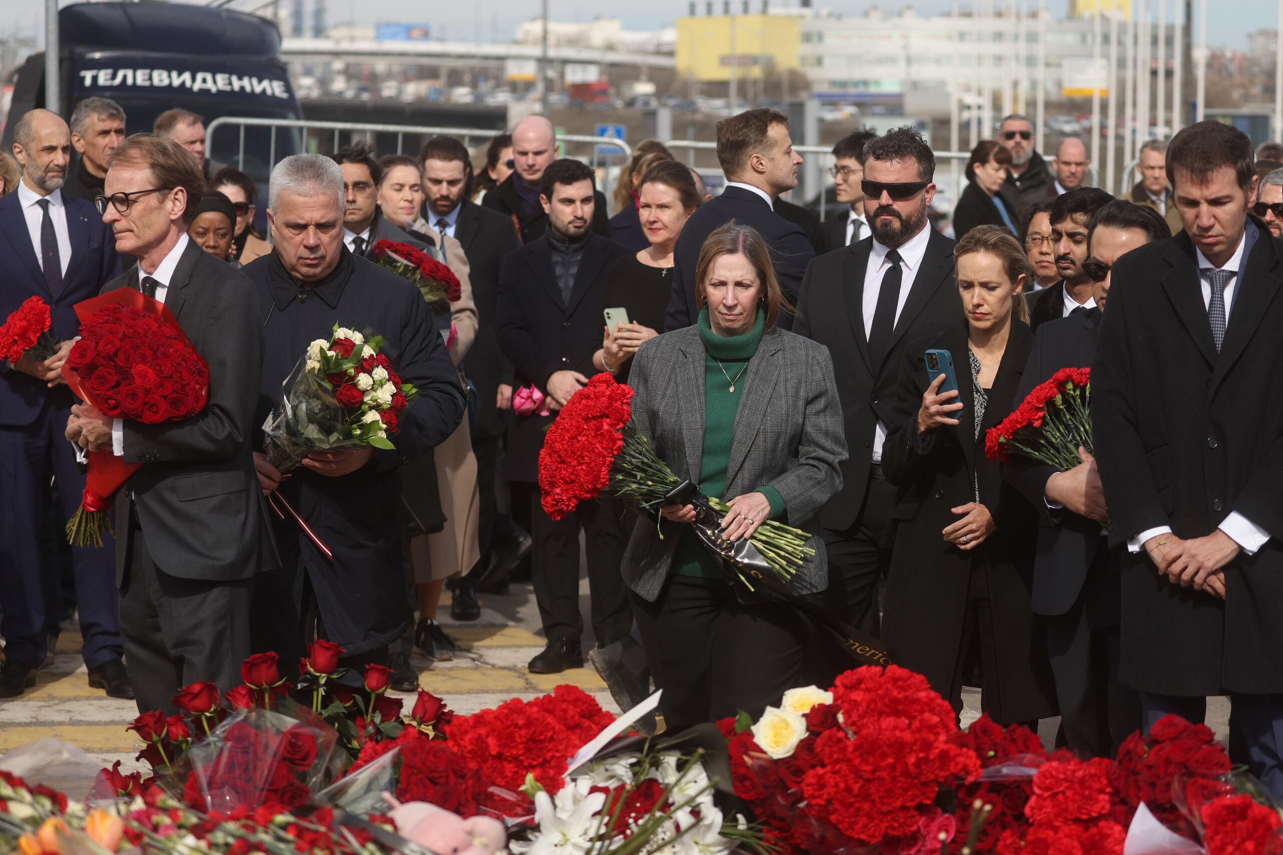 La embajadora estadounidense a Rusia, Lynne Tracy (centro), y otros embajadores colocan flores frente a la sala de conciertos Crocus City Hall en las afueras de Moscú, sábado 30 de marzo. (Sergei Ilnitsky/Pool Photo via AP)