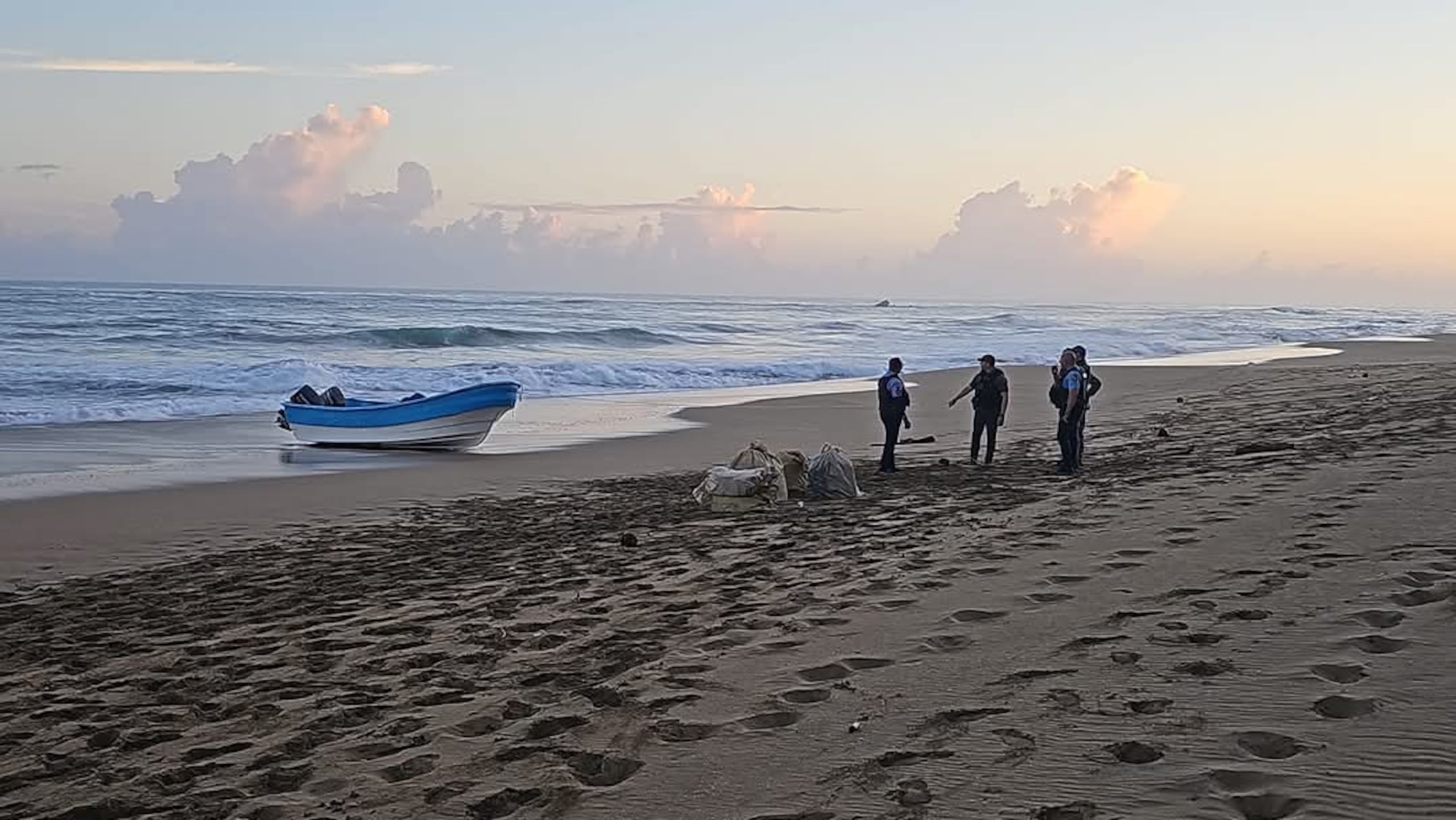 Agentes custodian los 15 fardos de droga ocupada.