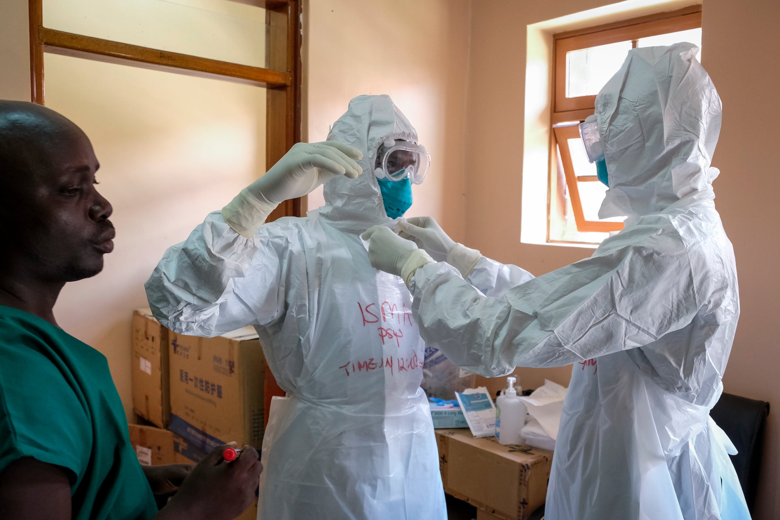 Imagen de archivo que muestra a médicos poniéndose equipos de protección para visitar a un paciente que estuvo en contacto con una víctima del ébola, en Uganda.