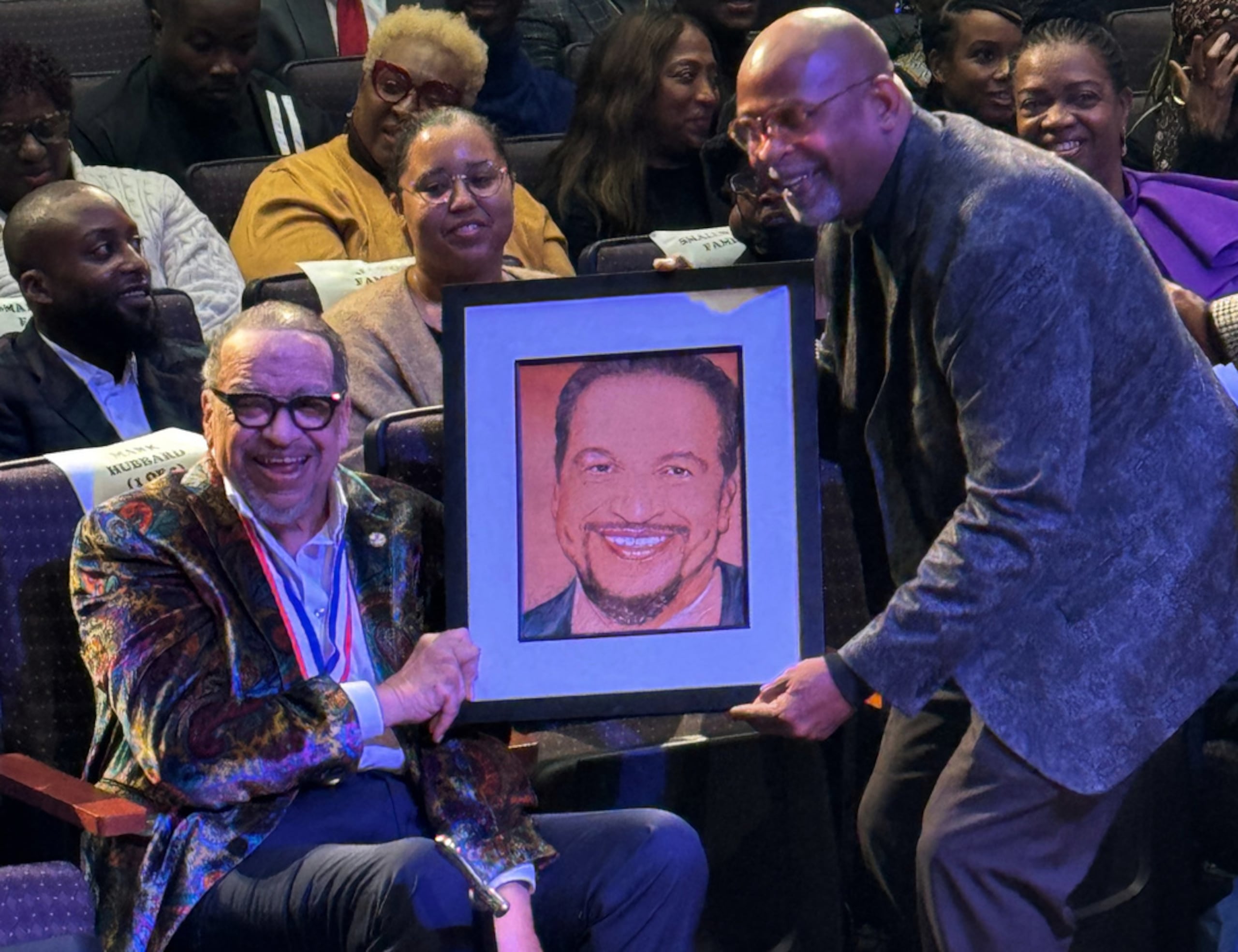Esta foto, proporcionada por Capital Entertainment, muestra al cantante de gospel nominado al Grammy, Richard Smallwood, recibiendo un retrato de sí mismo durante la celebración de su cumpleaños 75.