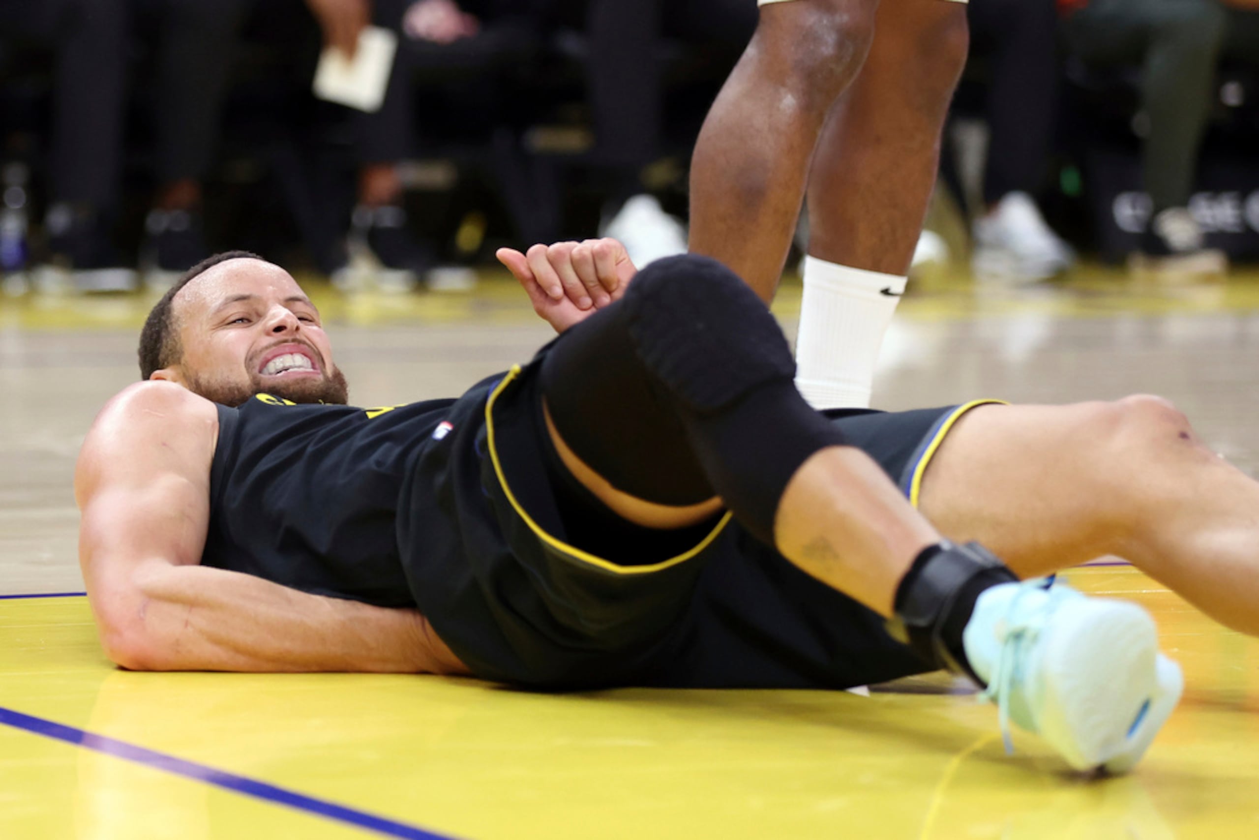 Stephen Curry hace una mueca de dolor tras una dura caída en el tercer cuarto contra los Toronto Raptors durante el partido de la NBA en el Chase Center de San Francisco el 20 de marzo de 2025.