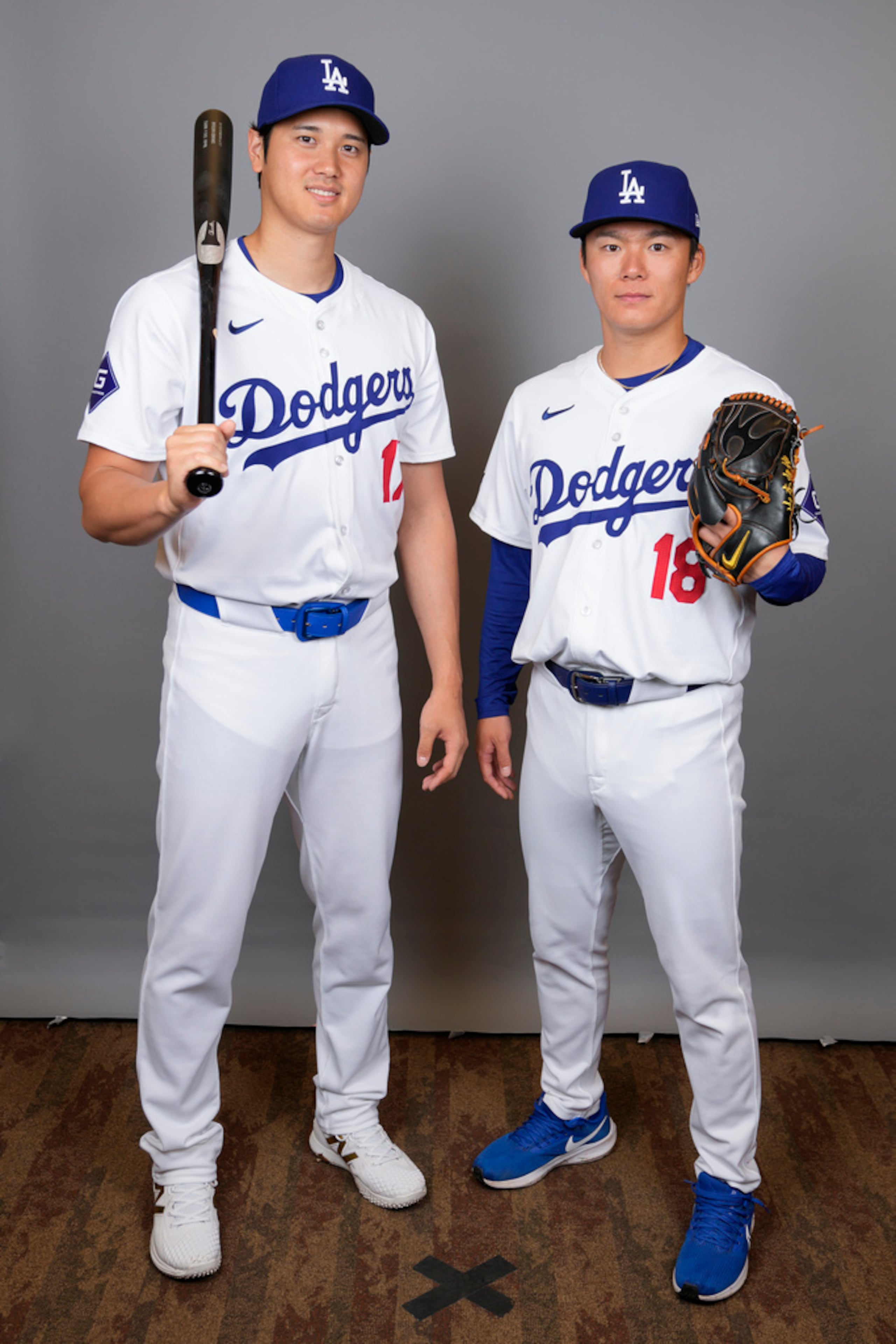 El bateador designado de los Dodgers, Shohei Ohtani, y el lanzador abridor Yoshinobu Yamamoto posan durante un día de fotos en los entrenamientos de primavera en Phoenix el 21 de febrero de 2024.