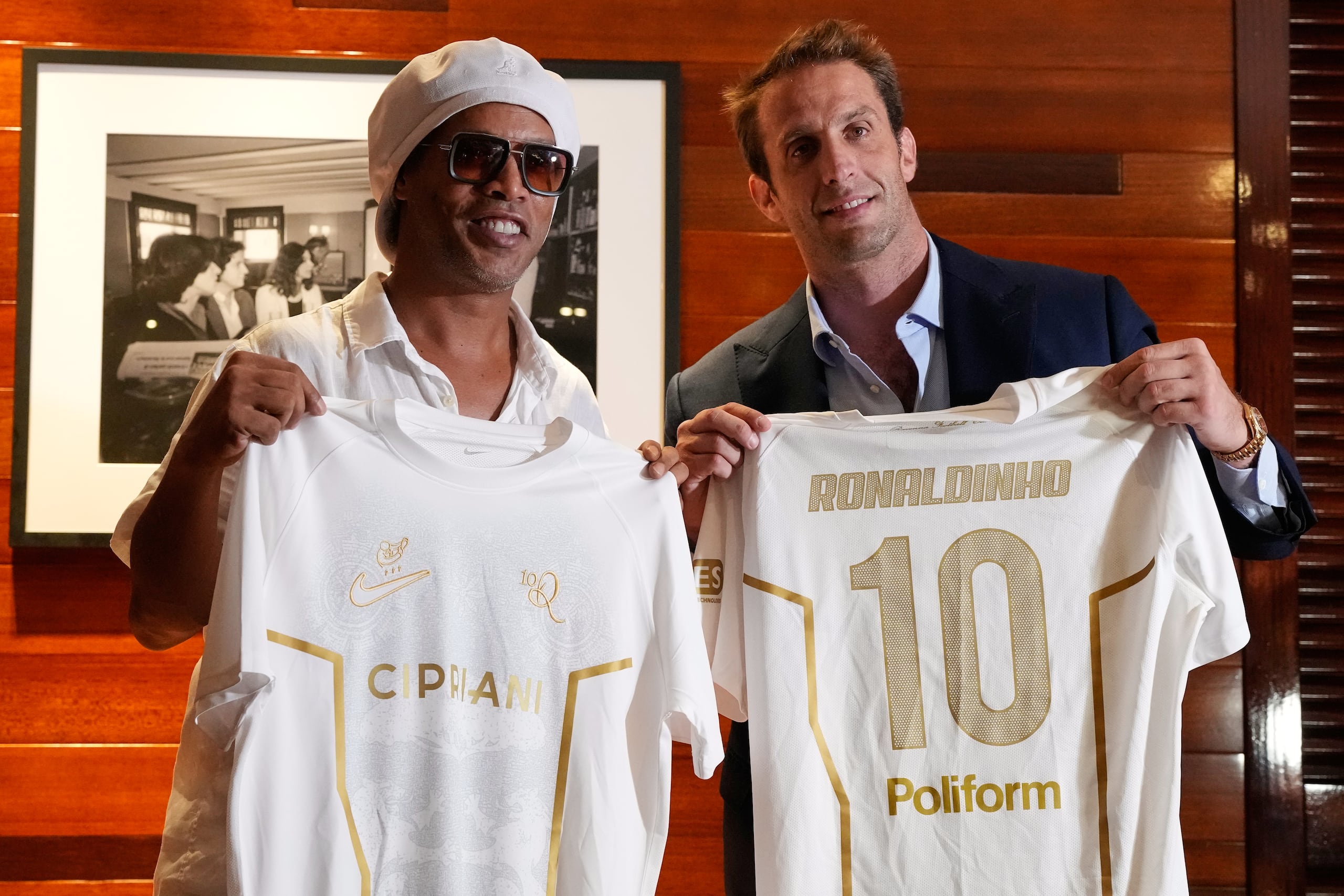El astro brasileño Ronaldinho sostiene una camiseta del Ravenna FC de la Serie C de Italia junto al presidente del equipo, Ignazio Cipriani.
