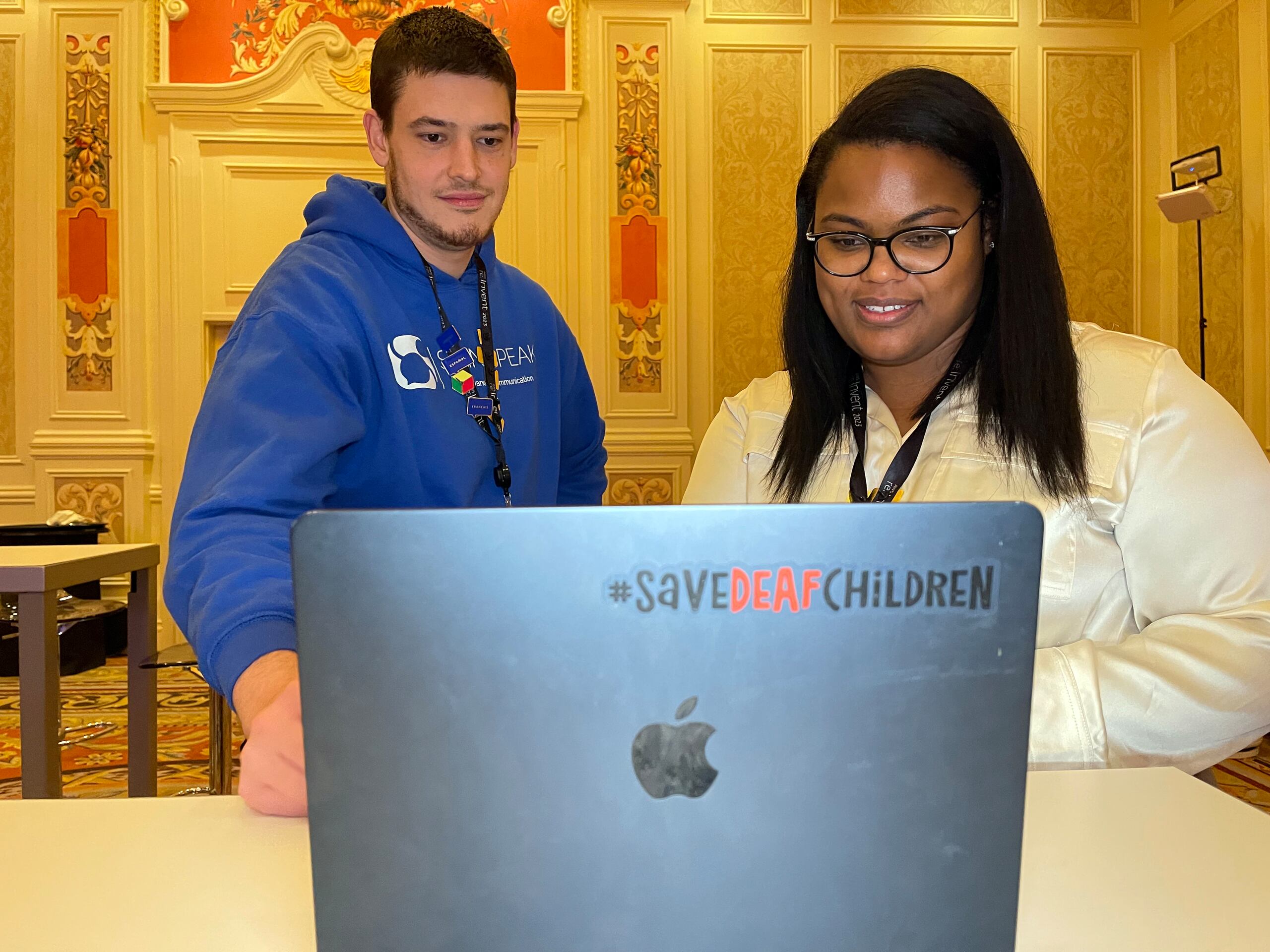 Yamillet Payano, cofundadora de la aplicación Sign-Speak, y Brian Hertneky, una persona con discapacidad auditiva que usa esta herramienta que traduce el lenguaje de señas a voz y texto y viceversa, observan los resultados de su conversación en una computadora.