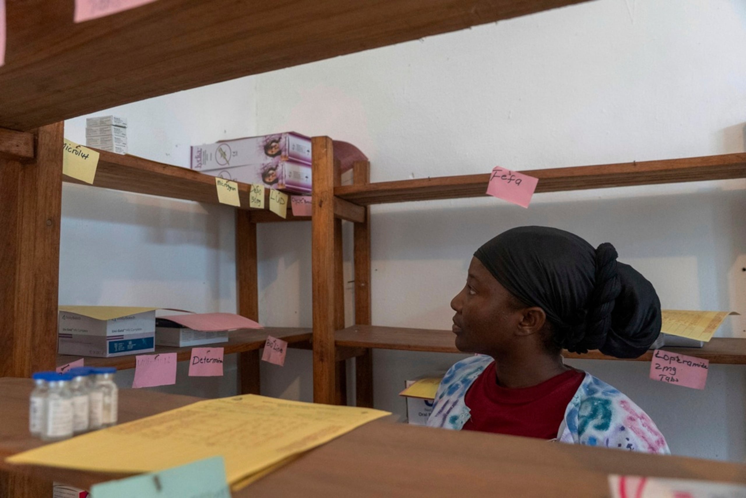 Irene A Kerkulah, funcionaria de salud a cargo de la clínica Palala, mira una estantería casi vacía en la clínica, en la que solía haber anticonceptivos, en el condado de Bong, el viernes 13 de junio de 2025. (AP Foto/Annie Risemberg/Archivo)