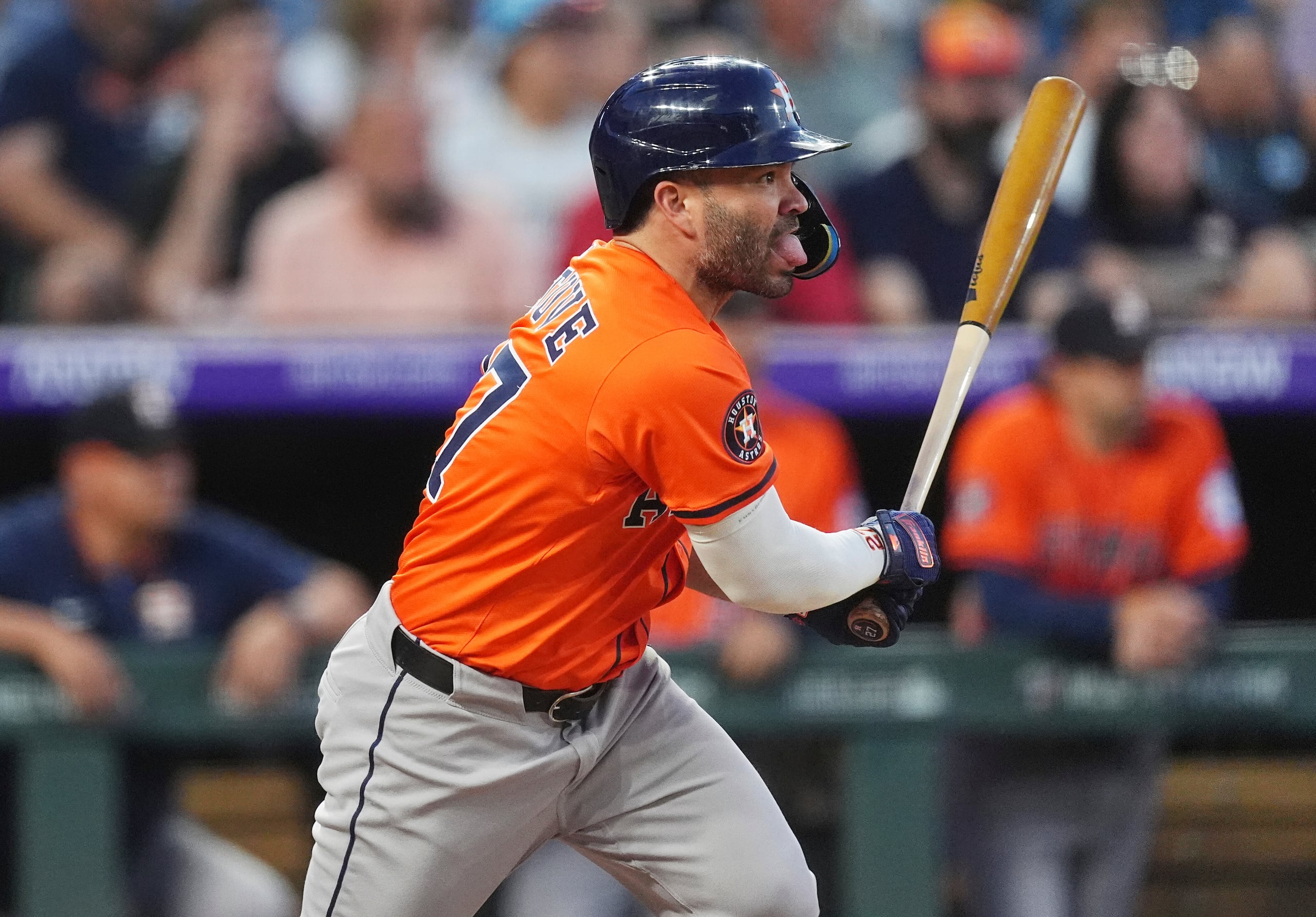 José Altuve, de los Astros de Hpuston, sigue el vuelo de la pelota de un sencillo que produjo dos carreras ante el relevista de los Rockies de Houston, Jake Bird.