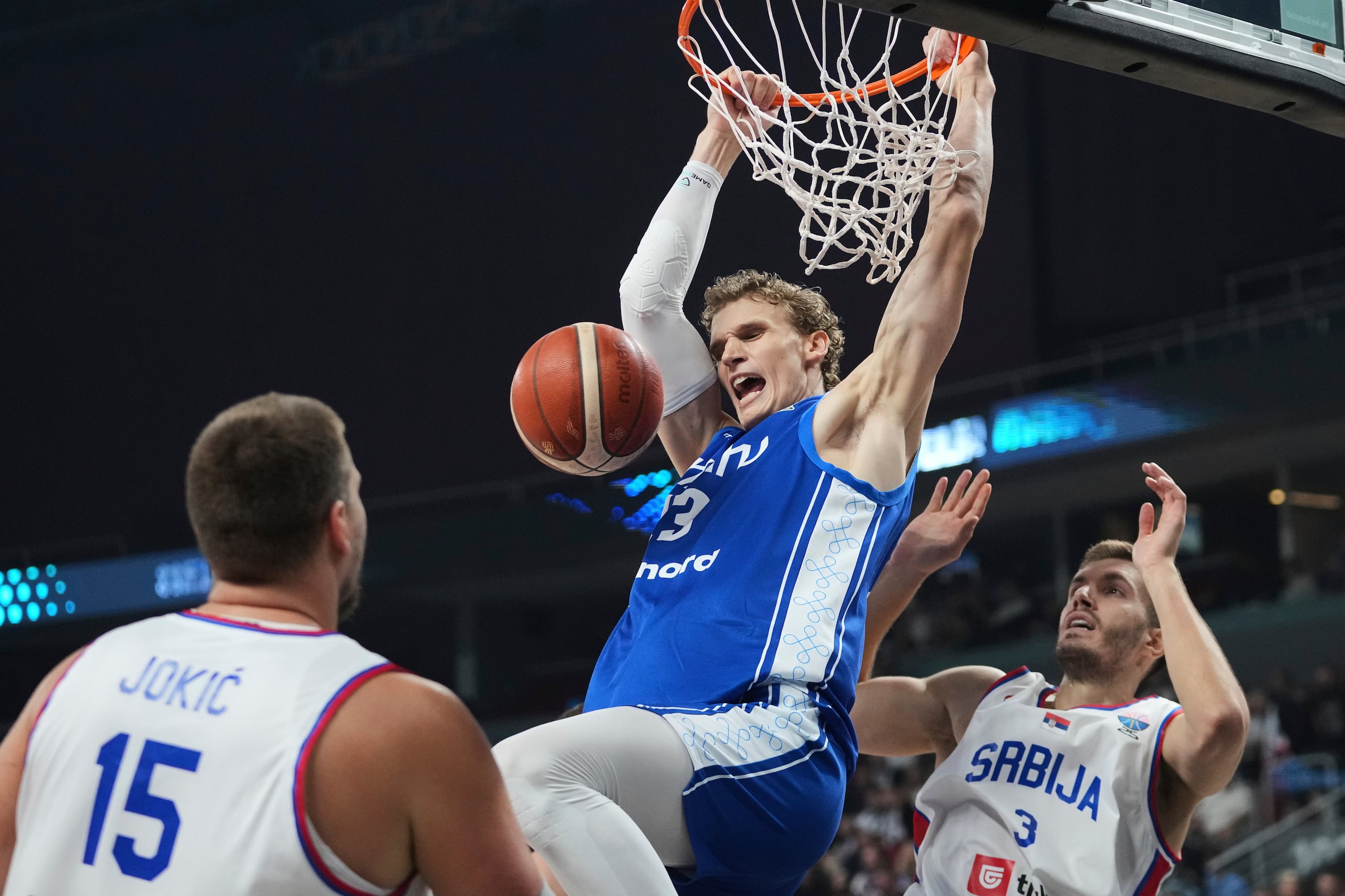 Lauri Markkanen, de Finlandia, donquea frente a la defensa de Serbia en los octavos de final del Eurobasket.