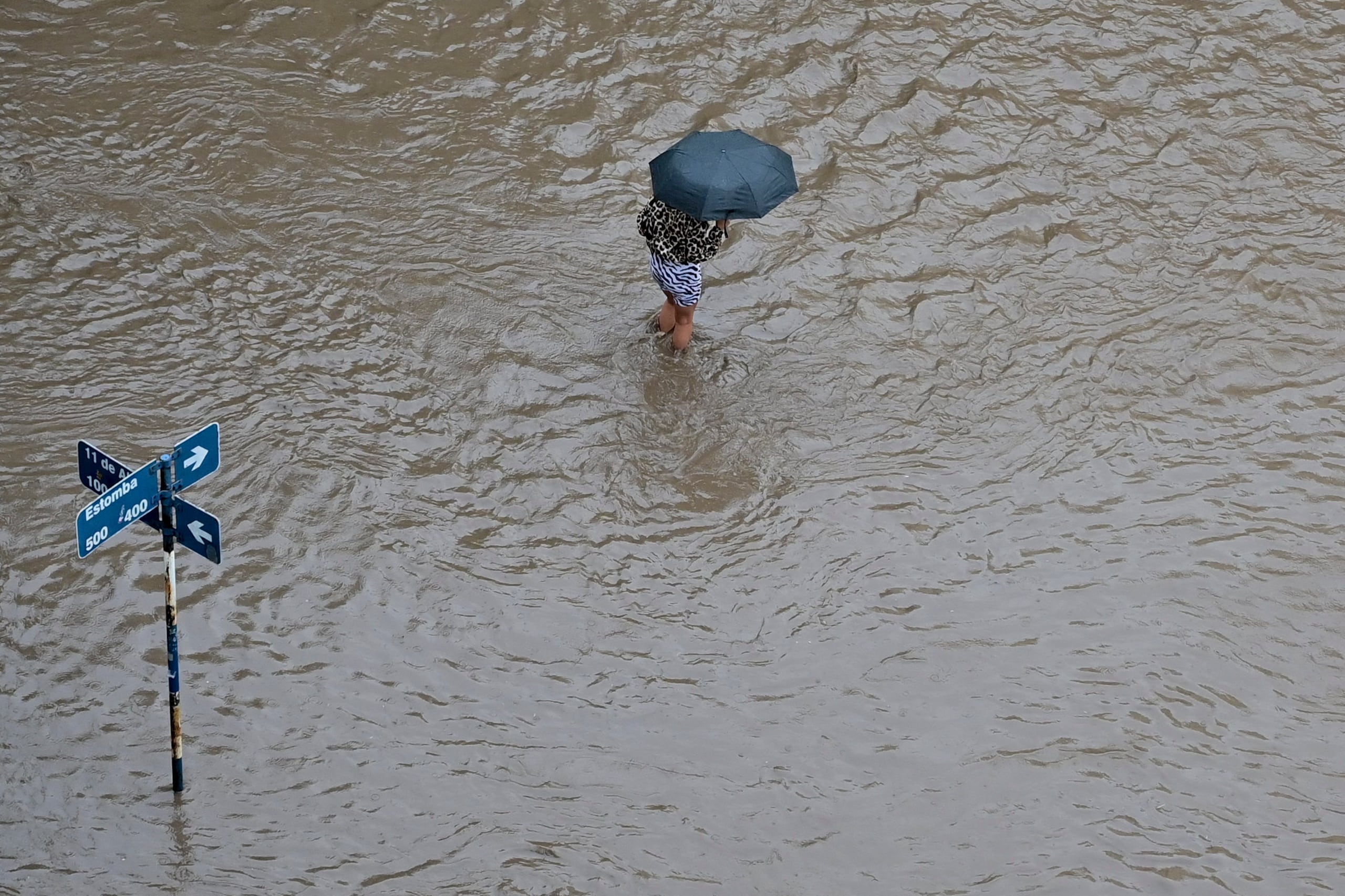 Una persona camina por una calle inundada después de una tormenta en Bahía Blanca, Argentina.