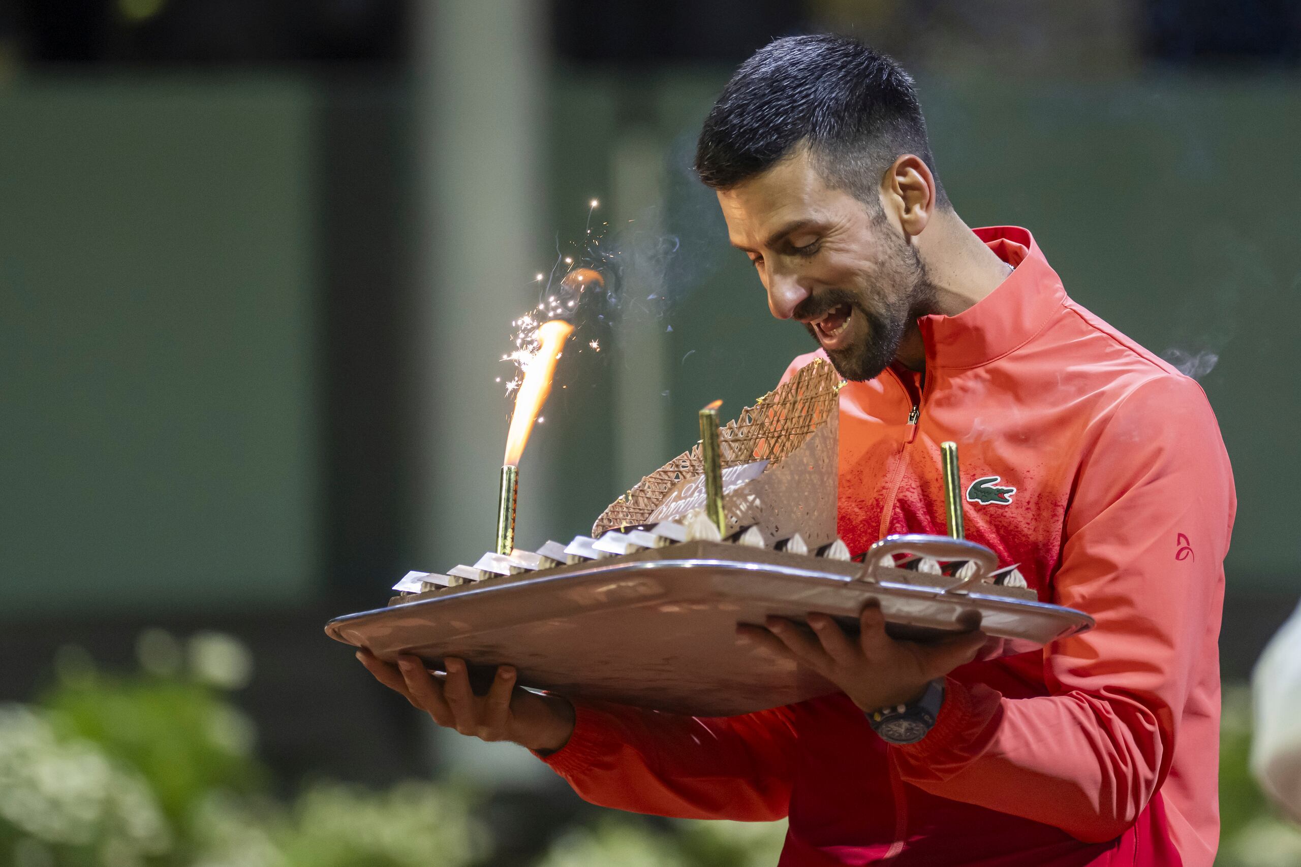 El serbio Novak Djokovic sostiene un pastel para celebrar su cumpleaños al vencer al italiano Matteo Arnaldi en el Abierto de Ginebra el jueves 22 de mayo del 2025.
