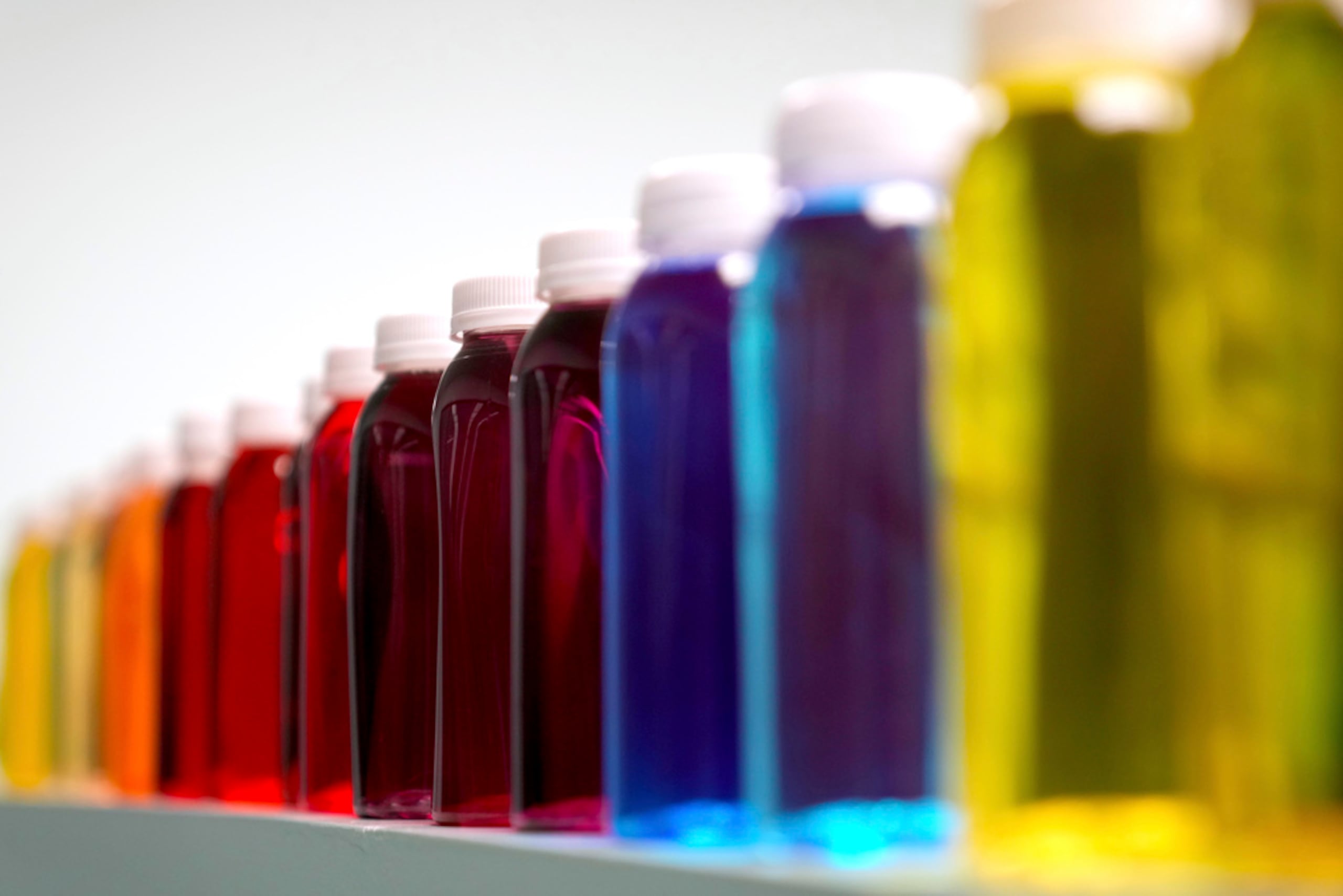 Botellas con una variedad de líquidos coloreados en una mesa de laboratorio de Sensient Technologies Corp., una empresa fabricante de aditivos de color de St. Louis., el 2 de abril de 2025.