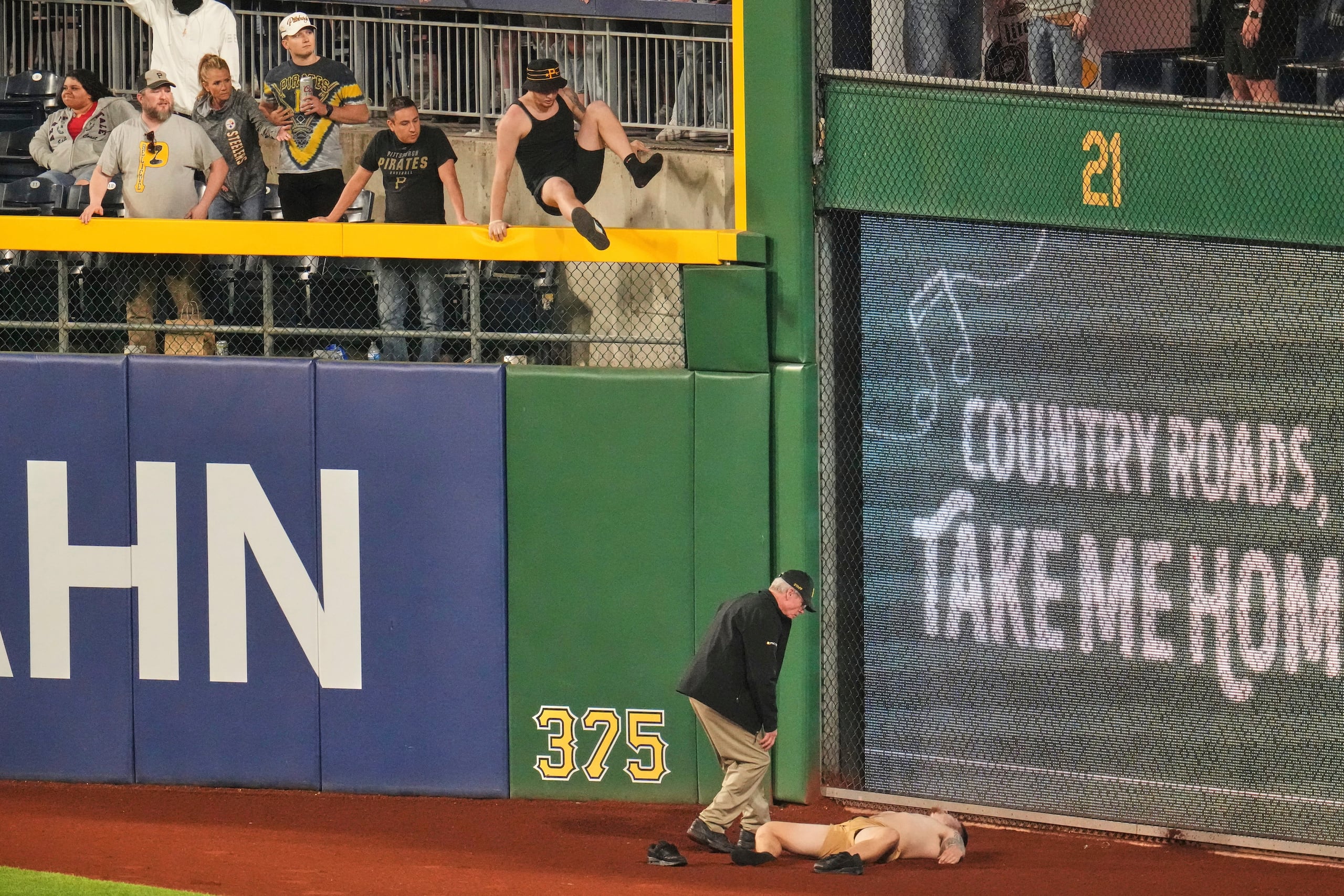 Un fanático yace en la fanja de advertencia del PNC Park, tras caer desde las gradas en el encuentro entre los Piratas de Pittsburgh y los Cachorros de Chicago, el miércoles 30 de abril de 2025 (AP Foto/Gene J. Puskar)