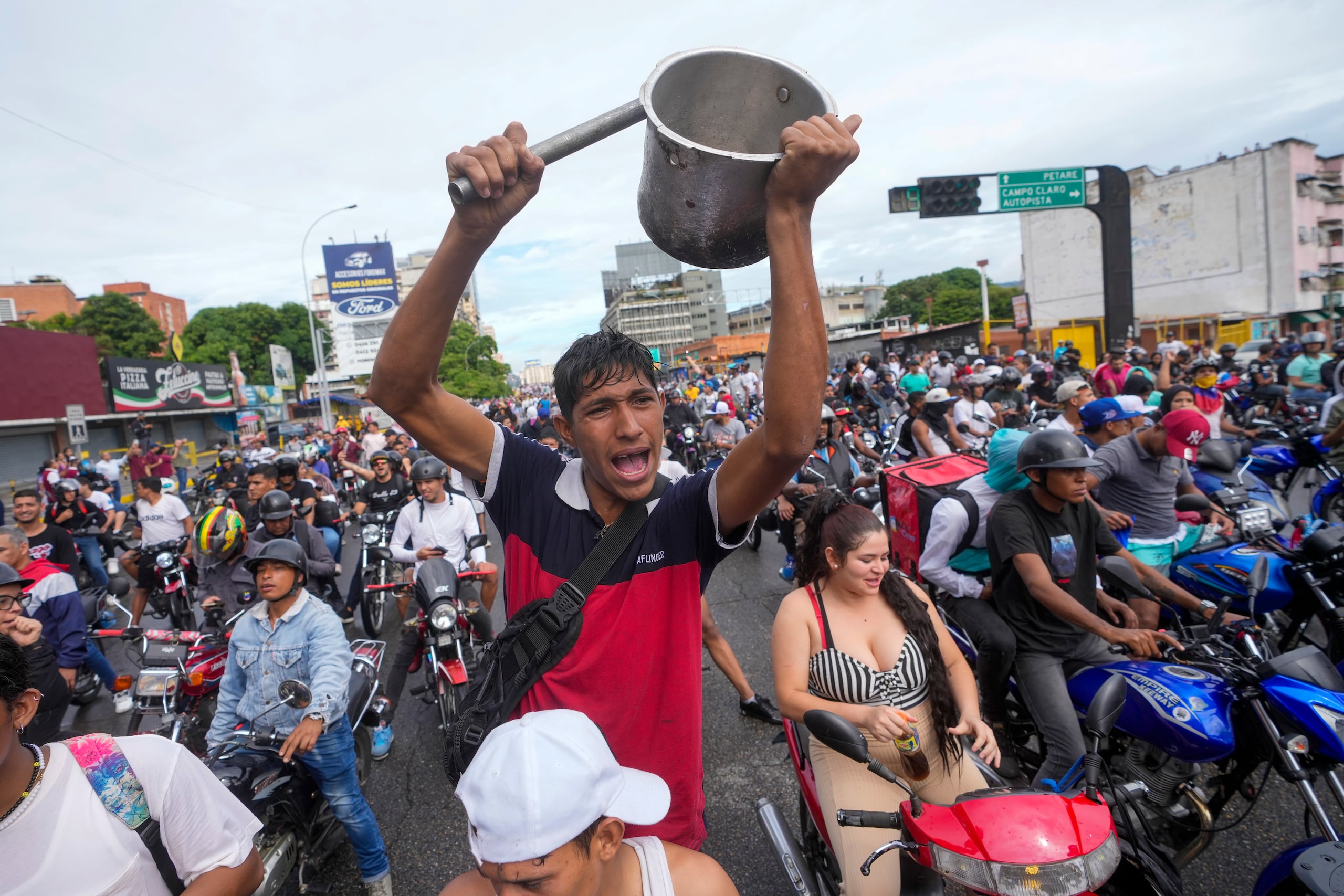 La gente protesta por los resultados oficiales de las elecciones que declararon al presidente Nicolás Maduro ganador de las elecciones presidenciales, el día después de la votación en Caracas, Venezuela. (AP Foto/Fernando Vergara)