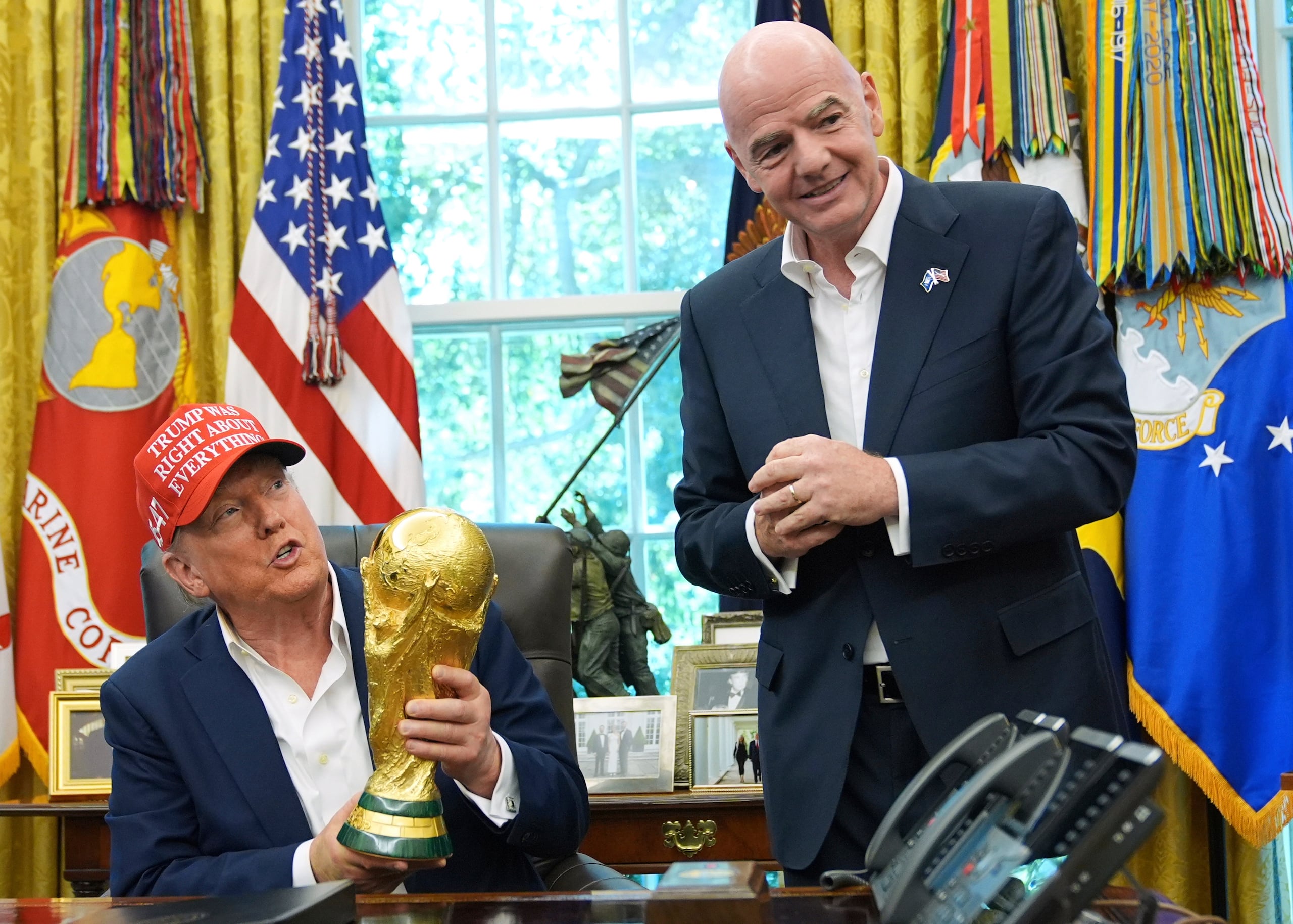 El presidente Donald Trump sostiene el trofeo de la Copa Mundial en una reunión en la Oficina Oval con el presidente de la FIFA, Gianni Infantino.