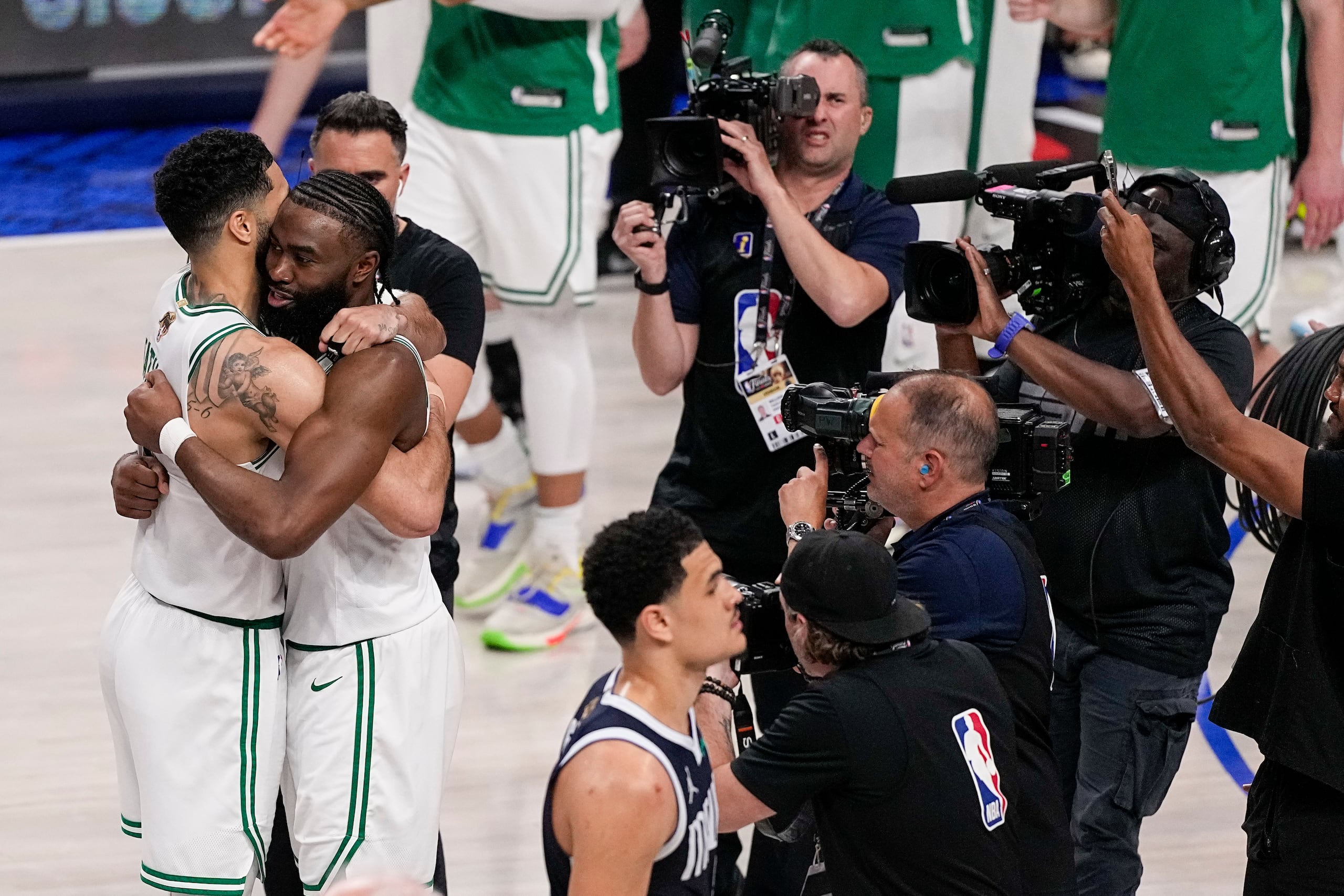 Jayson Tatum y Jaylen Brown se abrazan luego de resistir el empuje de los Mavericks en la segunda mitad del tercer partido.