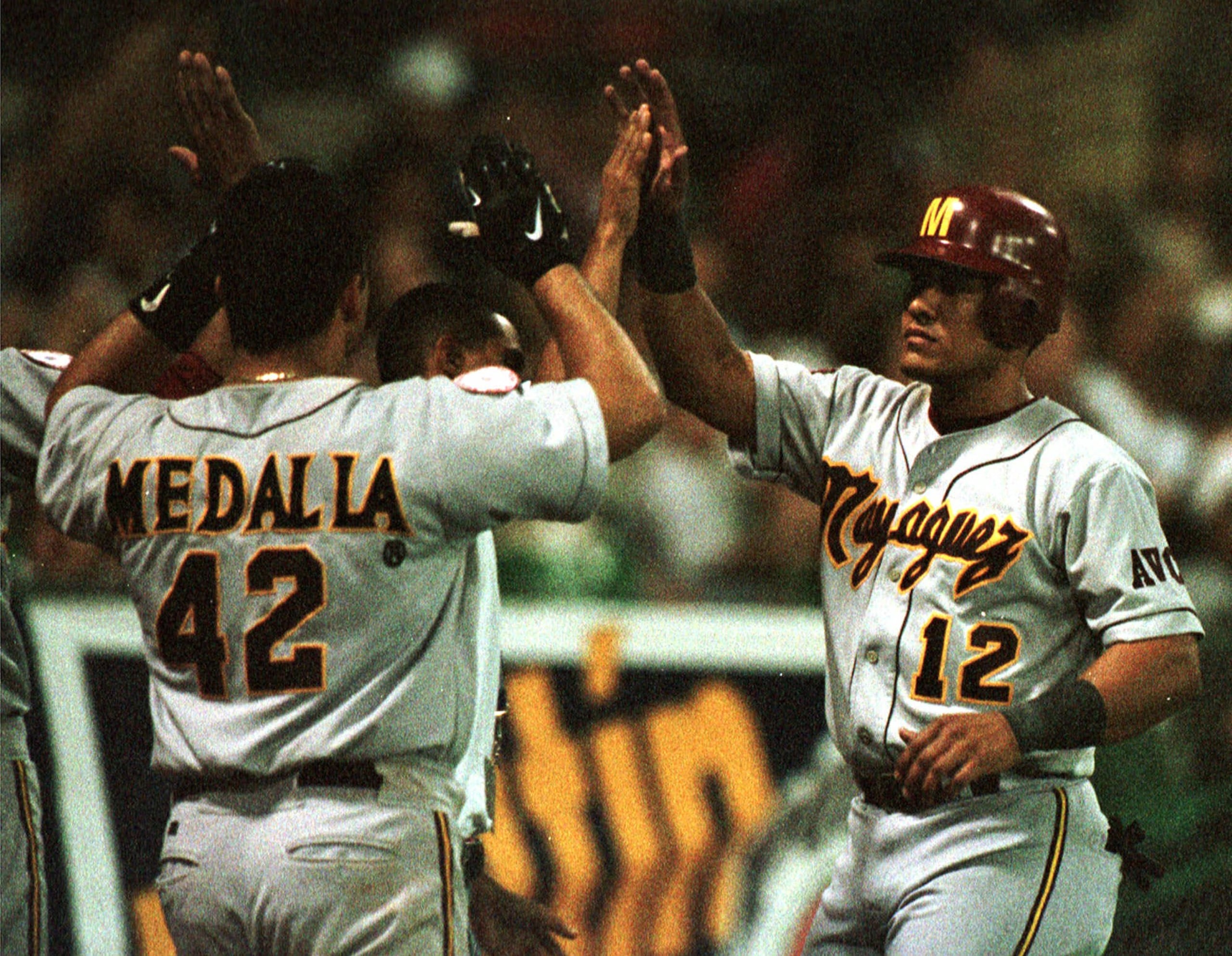 Wilfredo Cordero (12) es felicitado por Izzy Molina (42) después de anotar ante México en la Serie del Caribe de 1999 en el Estadio Hiram Bithorn.