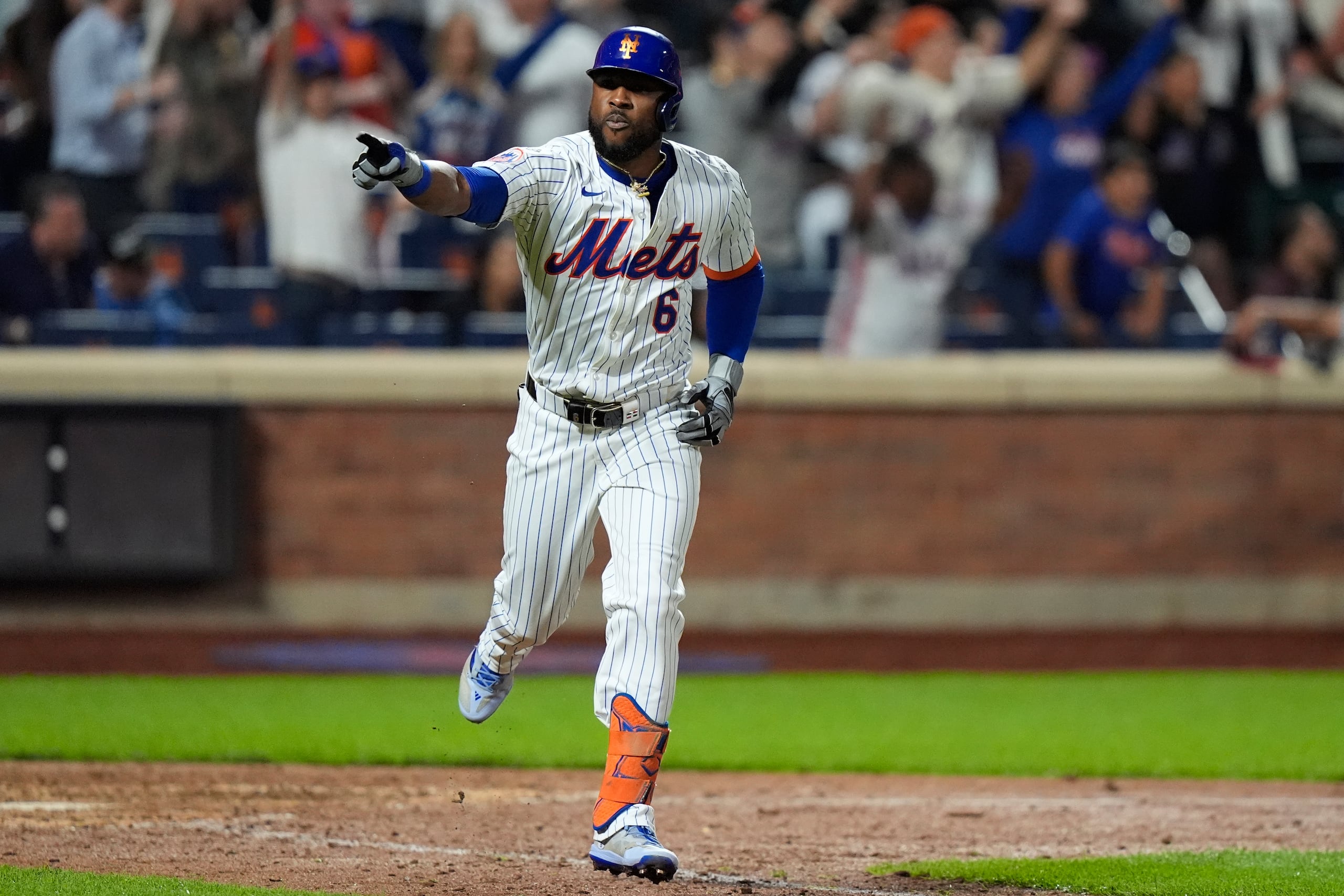 El dominicano de los Mets de Nueva York, Starling Marte, reacciona mientras corre hacia la primera base tras conectar un sencillo remolcador en el décimo episodio del juego de béisbol ante los Nationals de Washington.