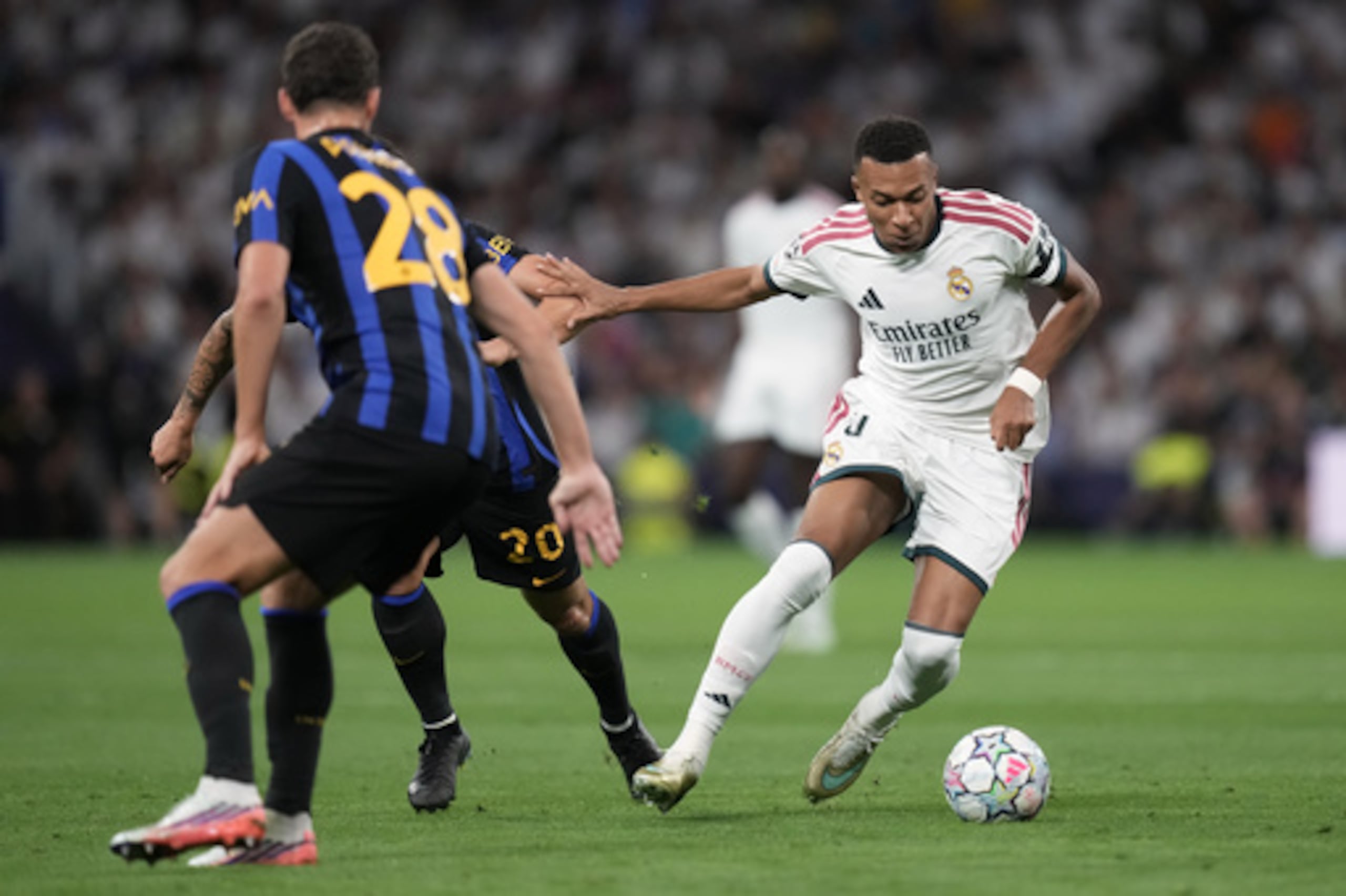 Kylian Mbappé, del Real Madrid, lucha por el balón contra Hakan Calhanoglu, del Inter de Milán, antes de marcar el primer gol, durante un partido de fútbol de la Liga de Campeones entre el Real Madrid y el Inter de Milán, disputado en Madrid, España, el martes 8 de septiembre de 2026. (Foto AP/Bernat Armangue)