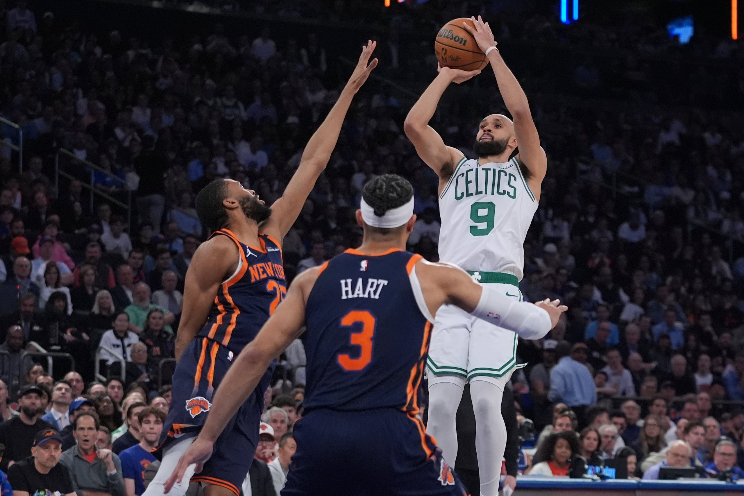 Derrick White, de los Celtics de Boston, lanza un triple ante la defensa de Josh Hart y Mikal Bridges, ambos de los Knicks de Nueva York.