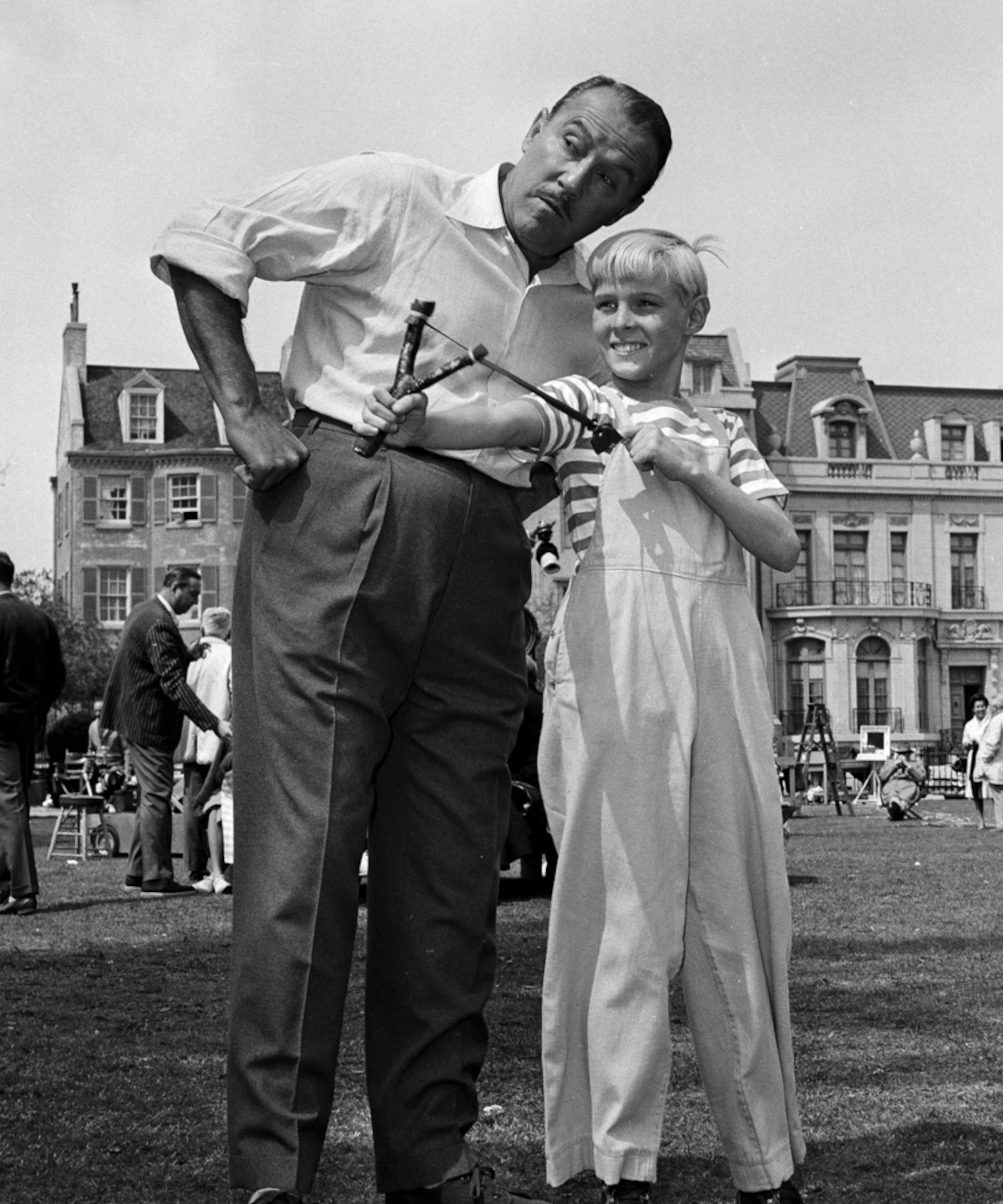 El actor Jay North, en su papel de Dennis, muestra su inseparable honda a su compañero de reparto Gale Gordon, en el set en Hollywood, el 29 de marzo de 1962.