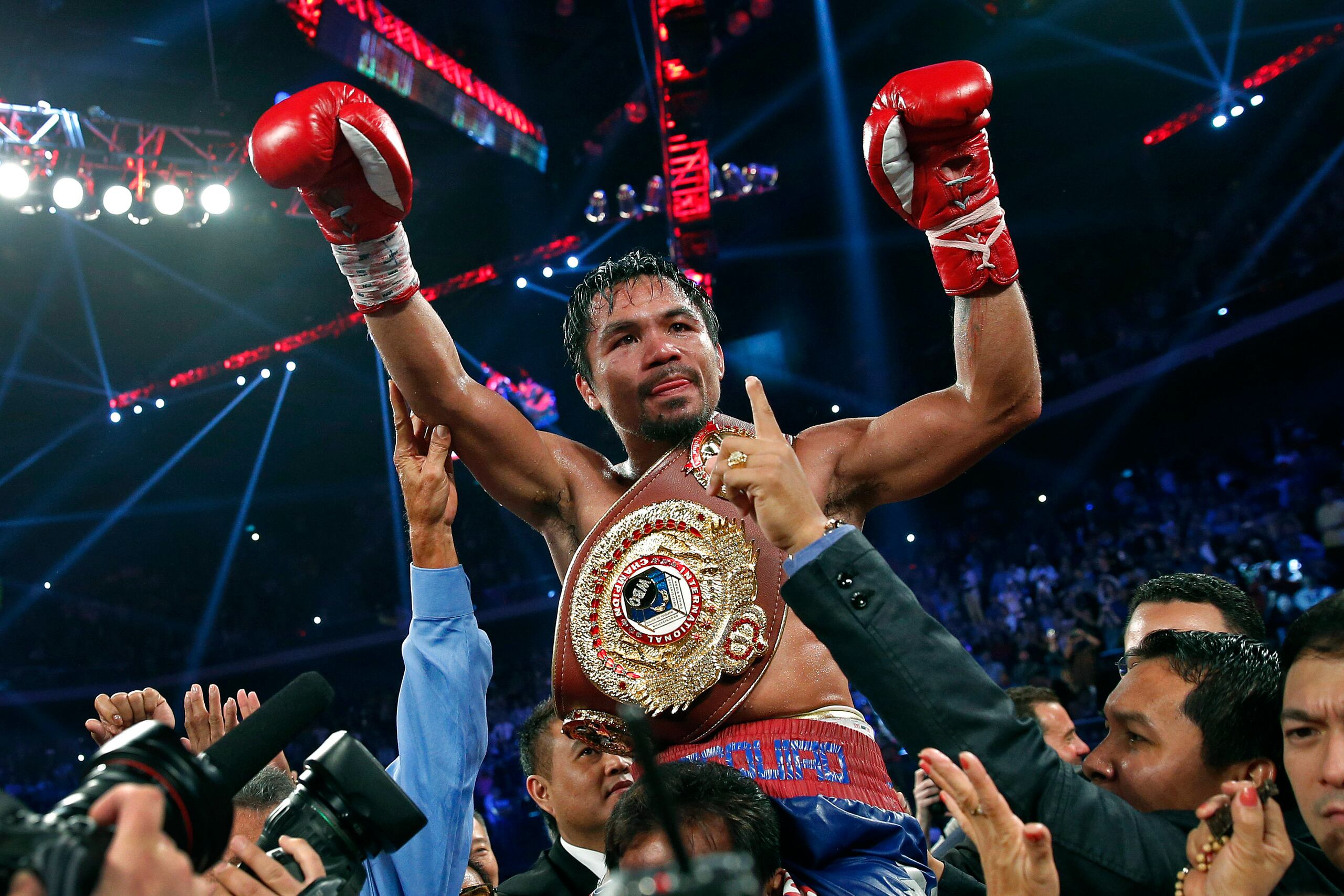 Manny Pacquiao exhibe su cinturón de campeón mundial tras derrotar a Brandon Ríos en la pelea por el cetro wélter del OMB, el 24 de noviembre de 2013, en Macau.