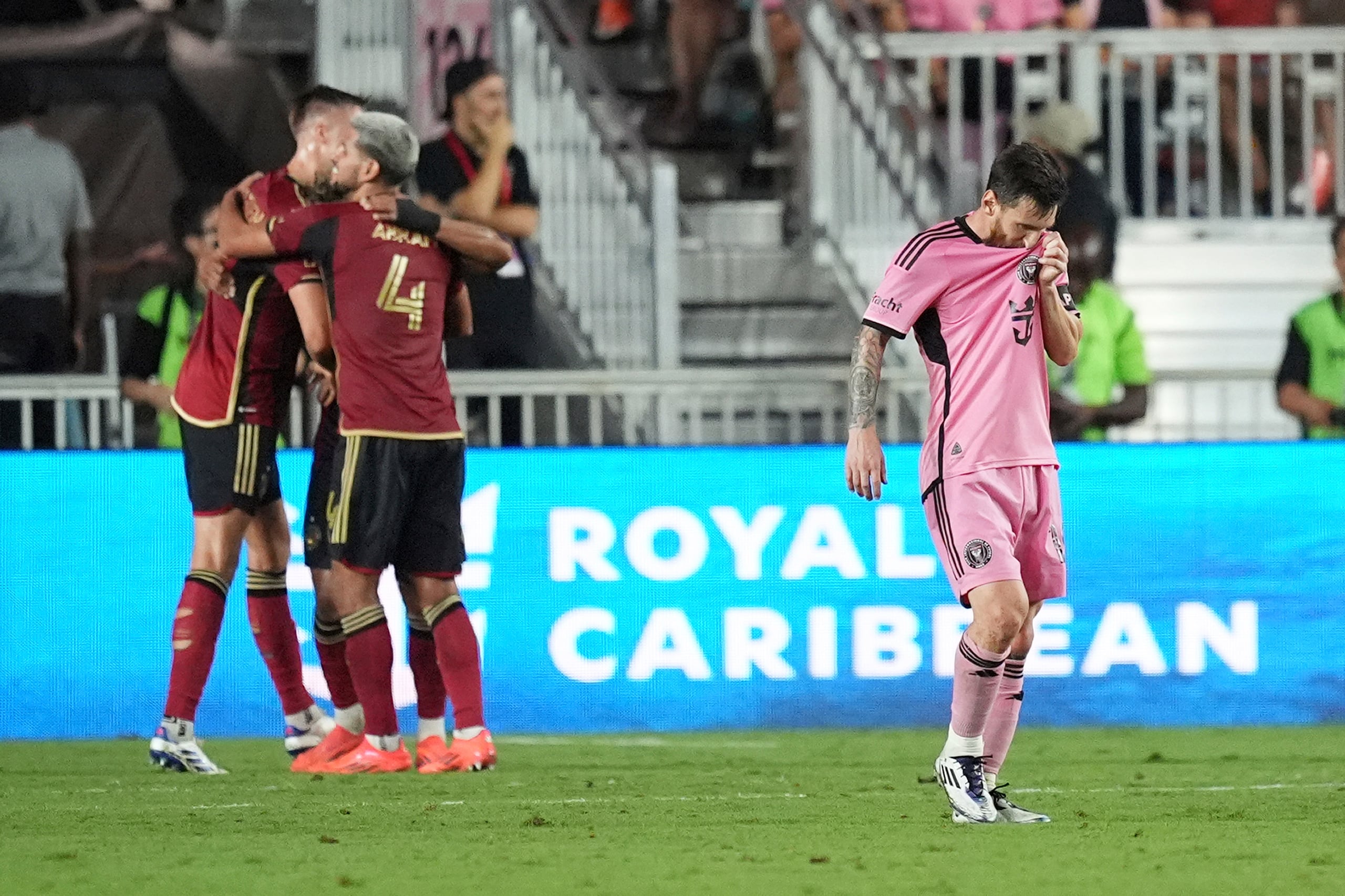Los jugadores del Atlanta United festejan, mientras Lionel Messi, del Inter Miami, abandona la cancha, tres el duelo de playoffs de la MLS.