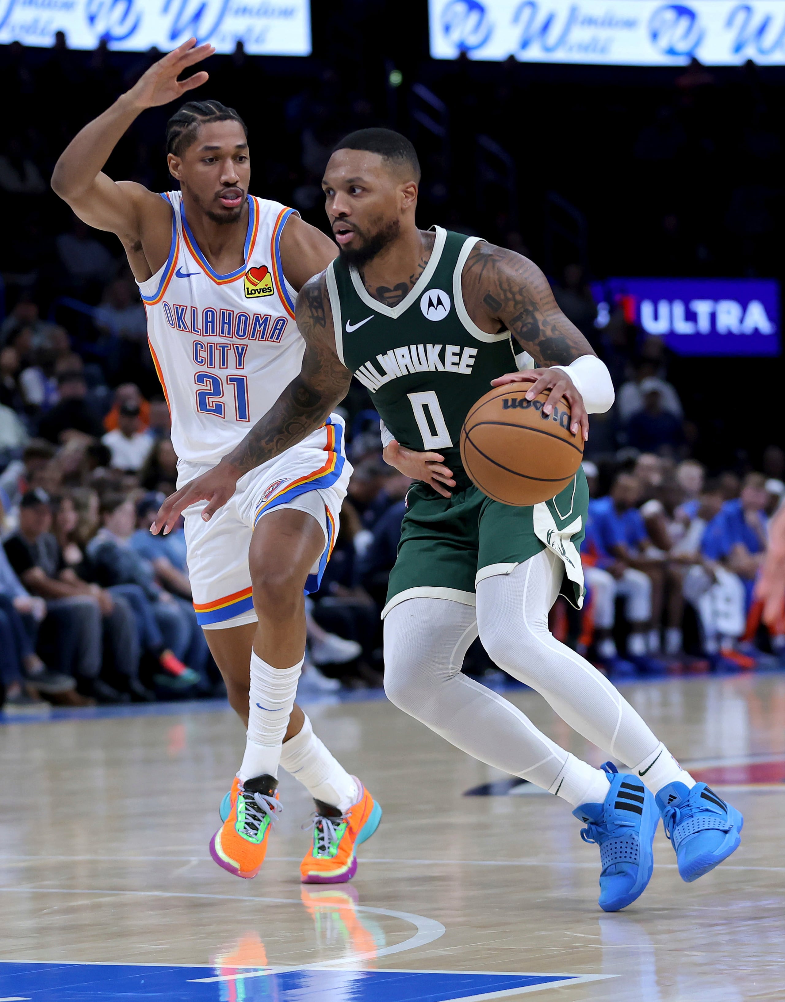 El nuevo armador de los Bucks de Milwaukee, Damian Lillard, ataca el canasto ante la defensa de Aaron Wiggins, del Thunder de Oklahoma.