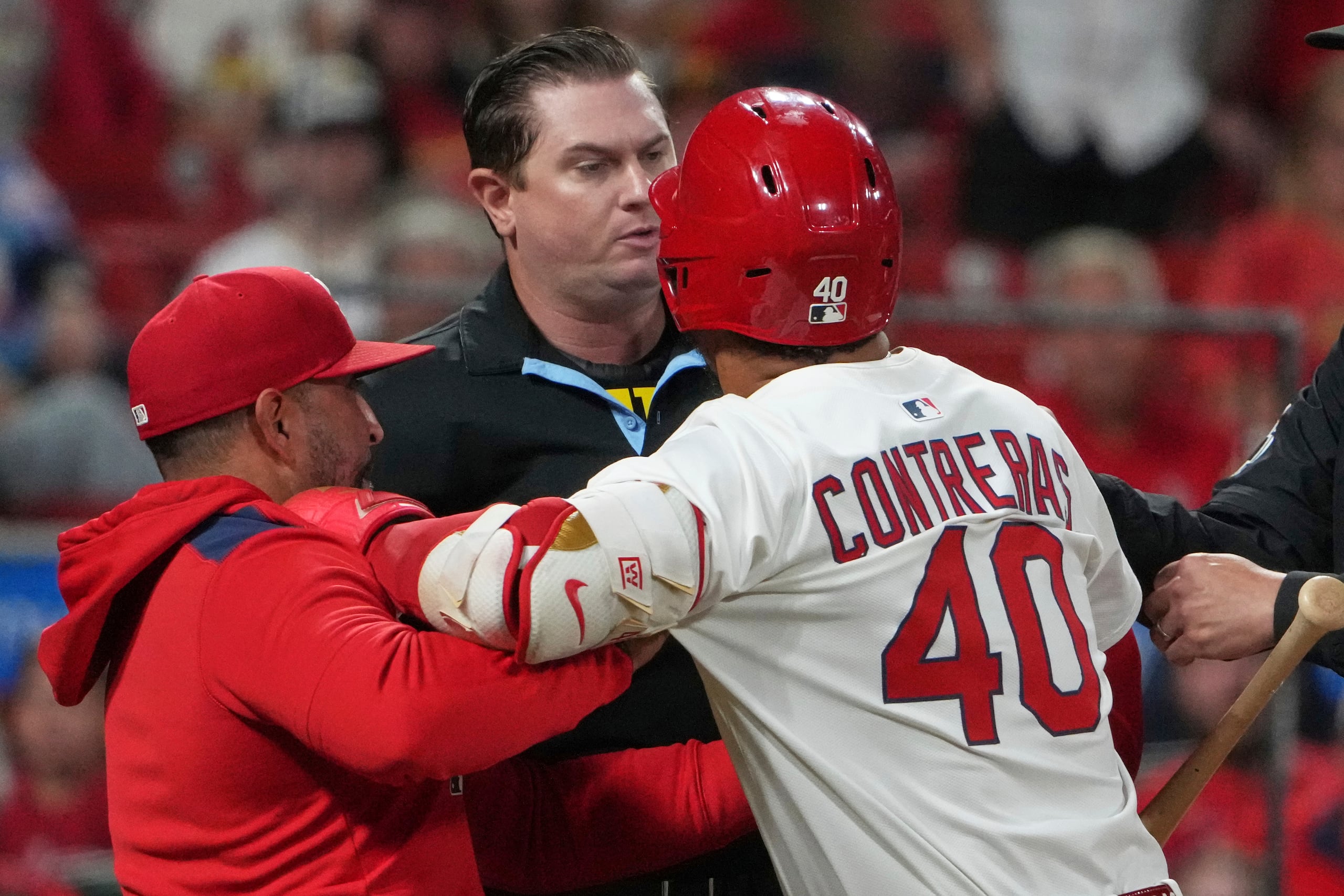 El mánager dominicano de los Cardinals de San Luis, Oliver Mármol, trata de alejar al pelotero venezolano Willson Contreras, quien discute con el umpire Derek Thomas en el encuentro del lunes 25 de agosto de 2025.