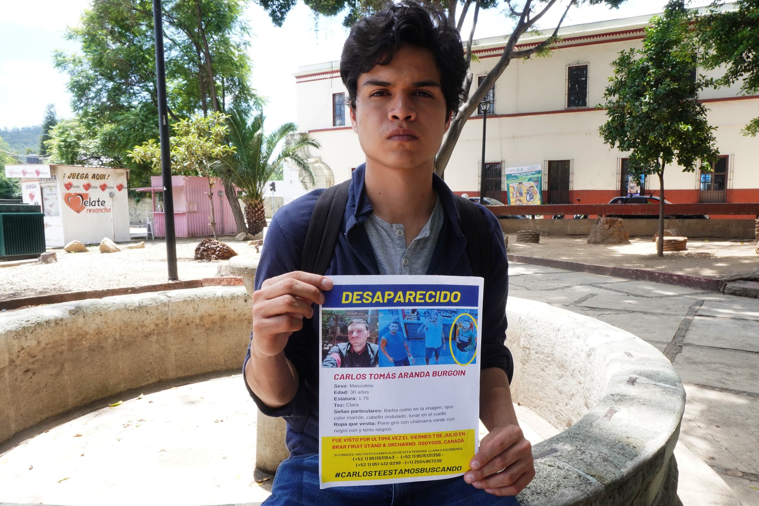 Josué Aranda Burgoin, hermano de Carlos muestra un cartel que emitió la Interpol sobre la desaparación de su hermano, hallado muerto por las autoridades canadienses más de un mes después de haber desaparecido.