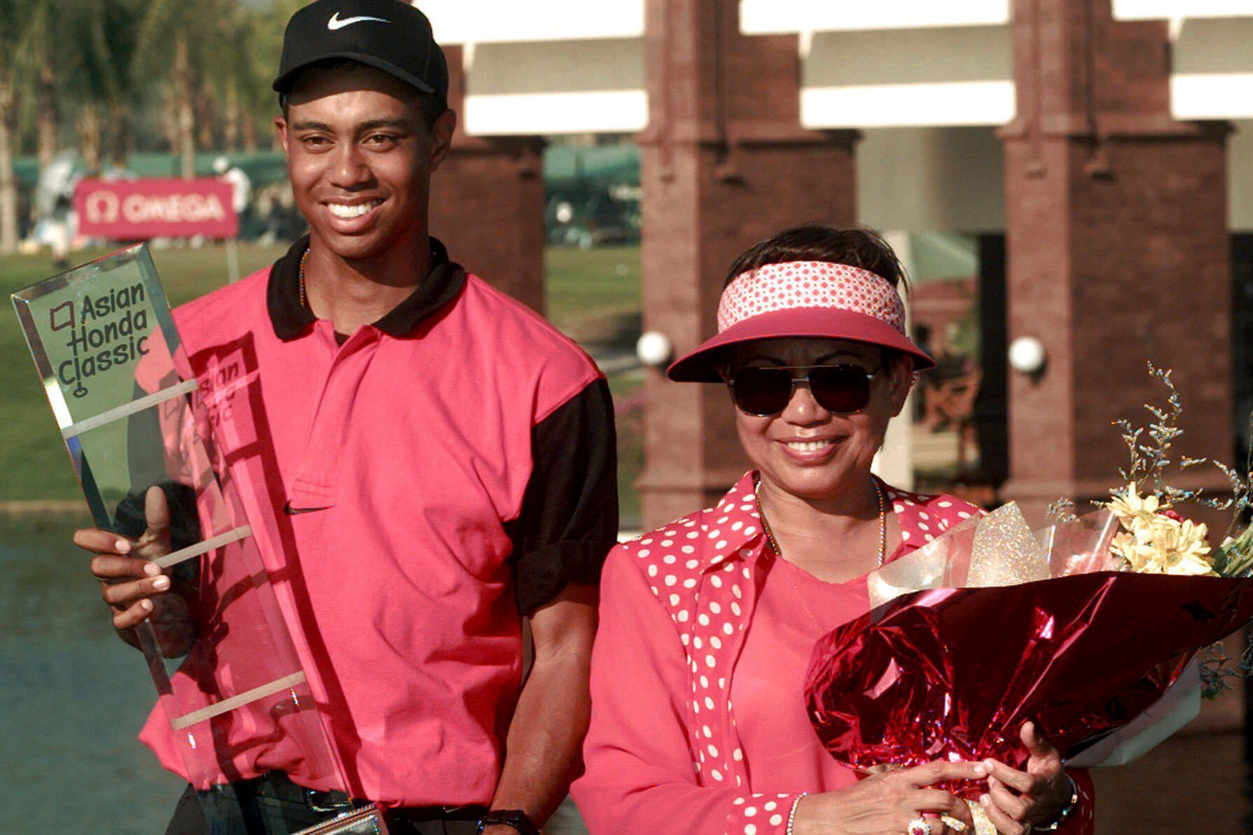 En esta foto del 9 de febrero del 1997, Tiger Woods posa con su madre al recibir un premio.