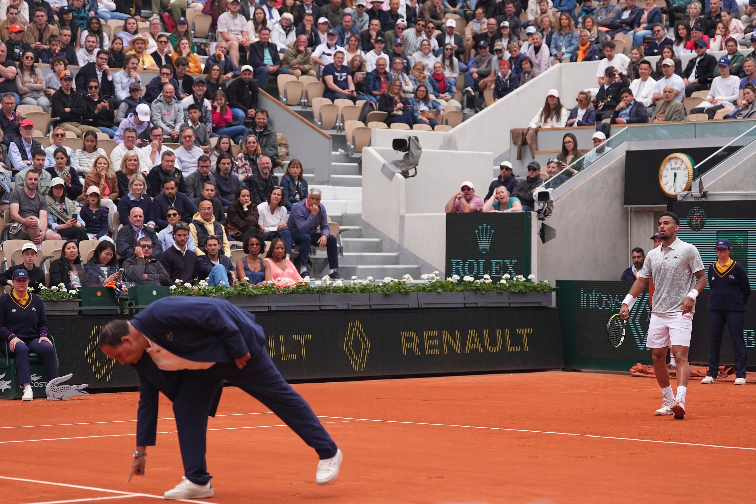 El juez de silla revisa una marca en la arcilla mientras Arthur Fils observa durante el partido contra Nicolás Jarry en el Abierto de Francia, el lunes 26 de mayo de 2025, en París.