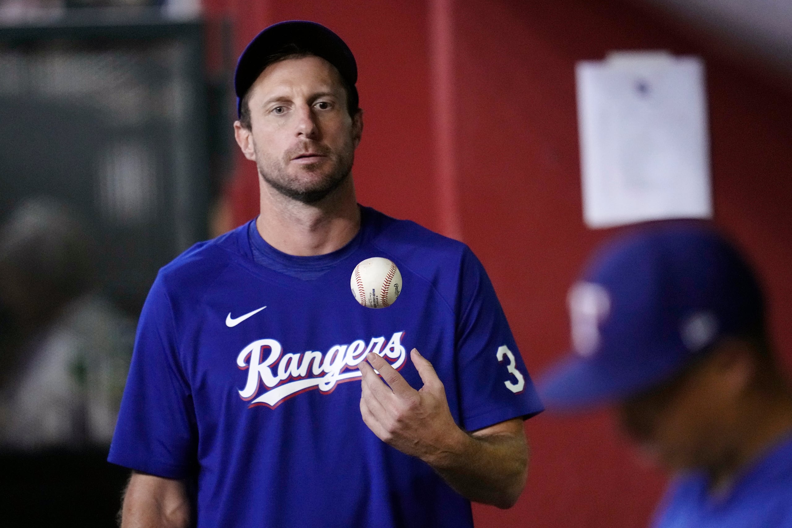 Max Scherzer juega con una pelota durante un momento en el dugout de los Rangers en el Citi Field el lunes.