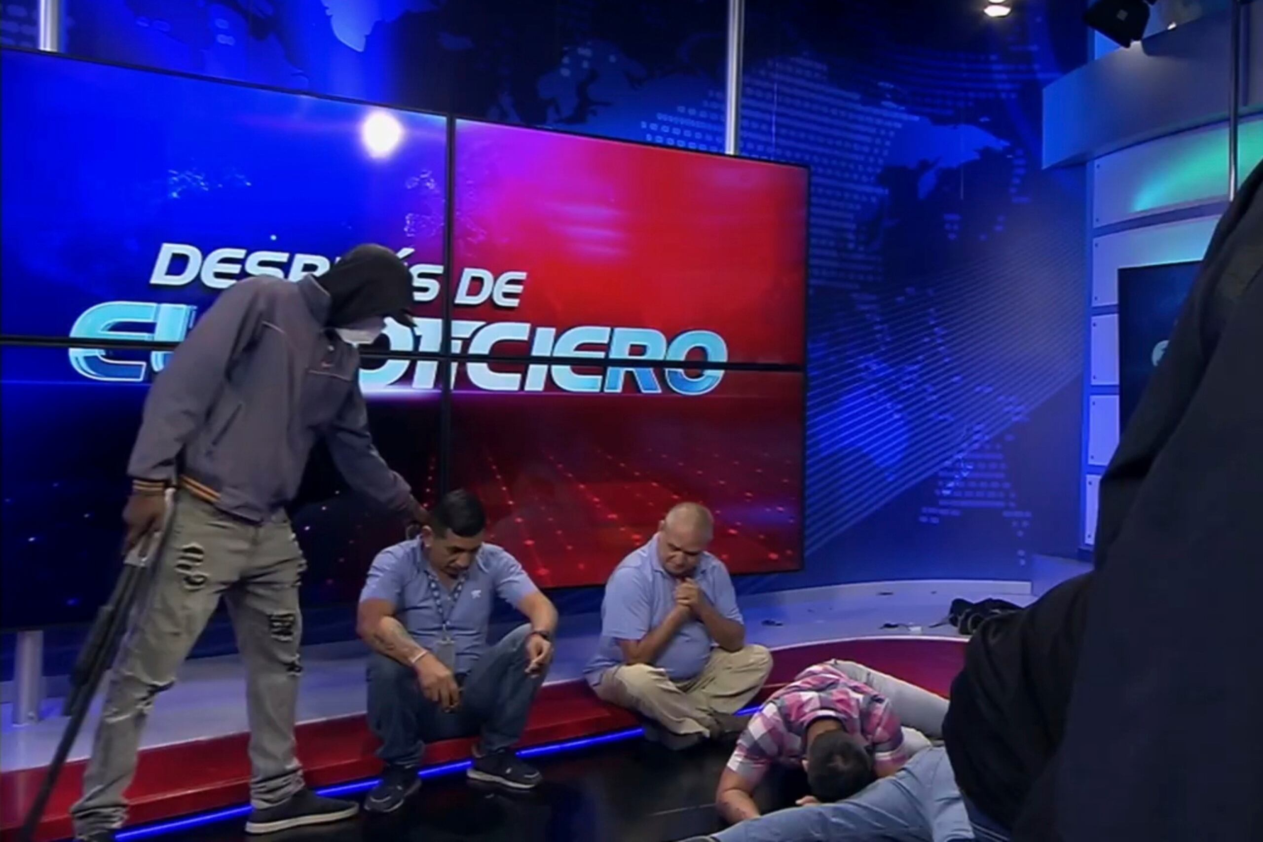 Imagen extraída del vídeo emitido por el canal TC Televisión en el que aparece un hombre encapuchado y armado al lado de dos trabajadores del medio en plena retransmisión en vivo, en Guayaquil, Ecuador, el 9 de enero de 2024.