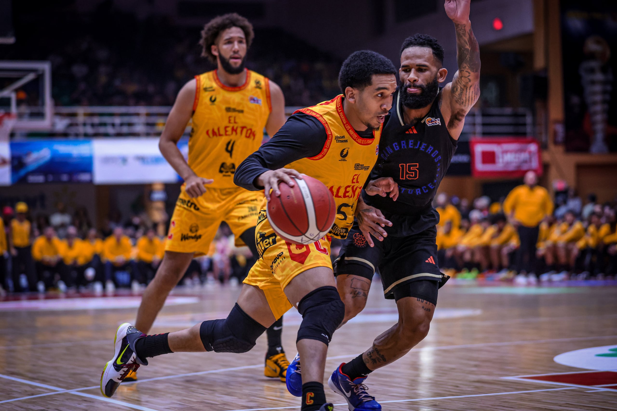 Tremont Waters, de los Gigantes de Carolina, maneja el balón frente a Walter Hodge, de los Cangrejeros de Santurce.